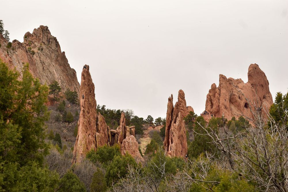 Towering red rock formations rise against a cloudy sky at Garden of the Gods park in Colorado Springs.