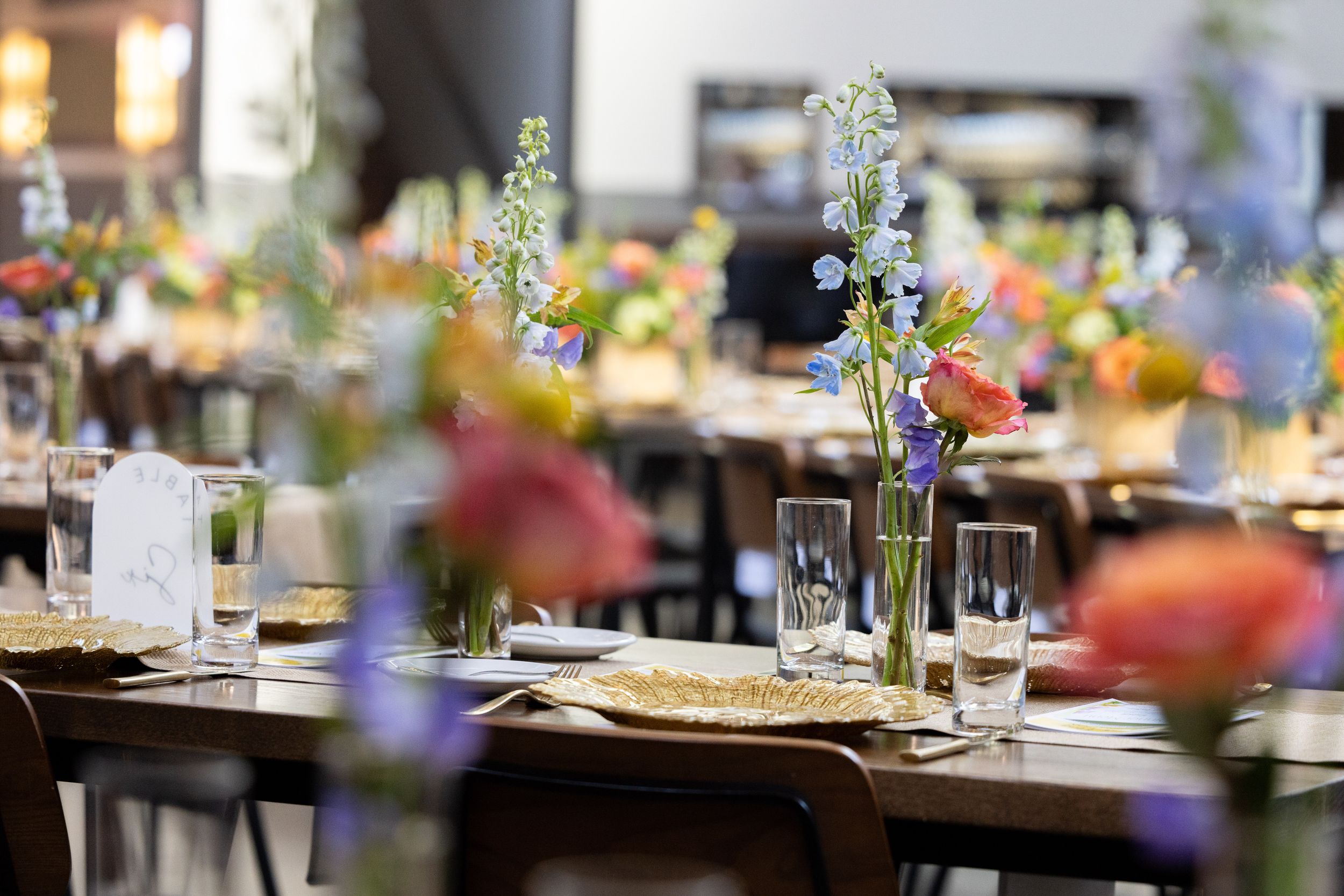 A table set with various dishes and floral arrangements in a cozy, indoor setting.