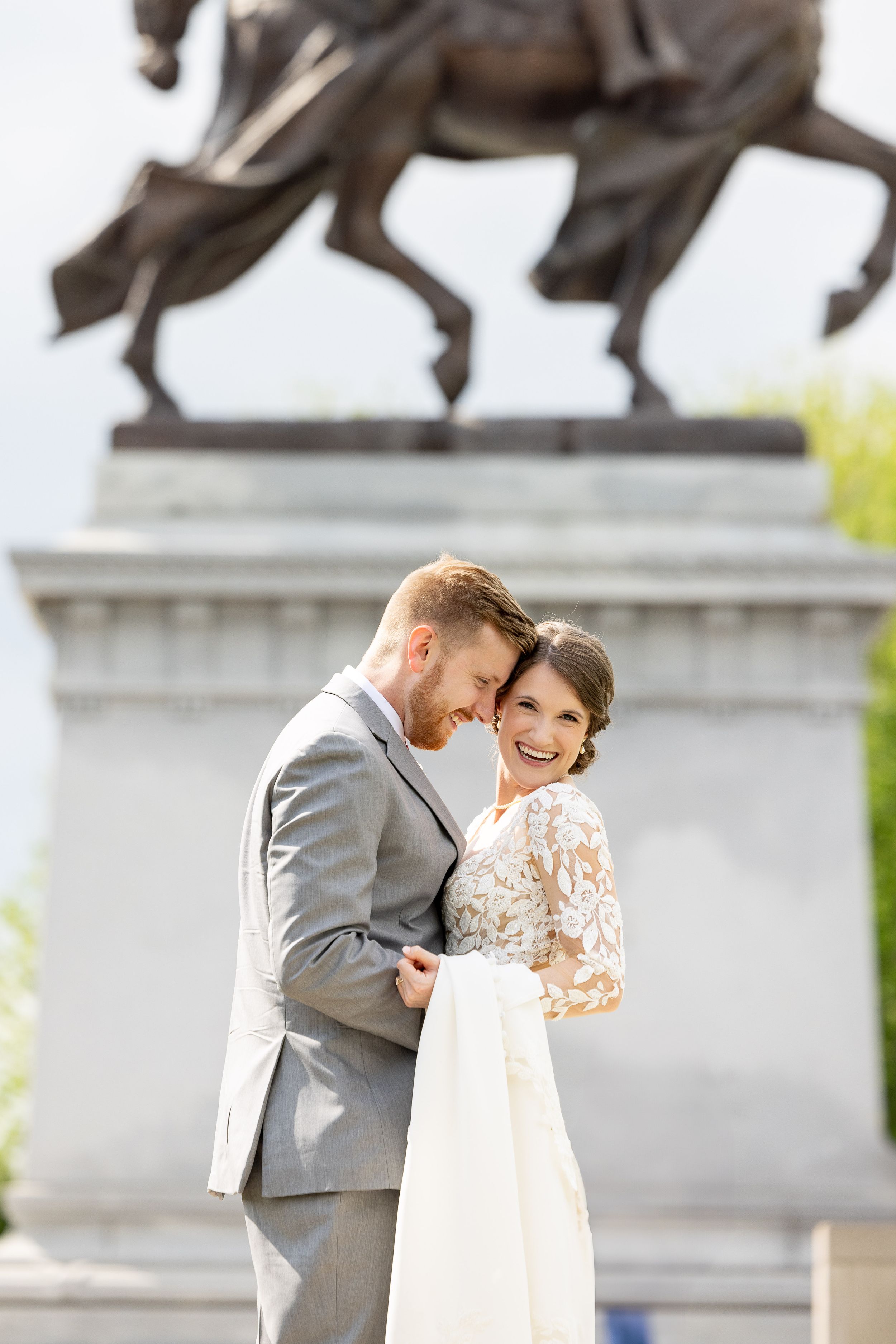 A bride and groom stand together in front of a vibrant, colorful mural backdrop.