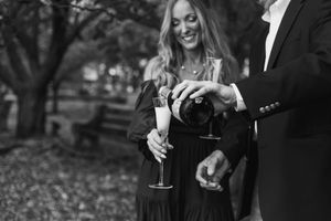 Elegant couple enjoying drinks and conversation at an outdoor gathering.