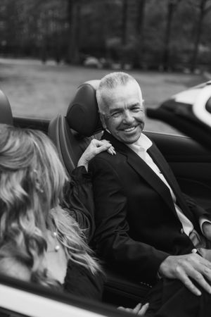 Black and white photo of a couple laughing together in a car.