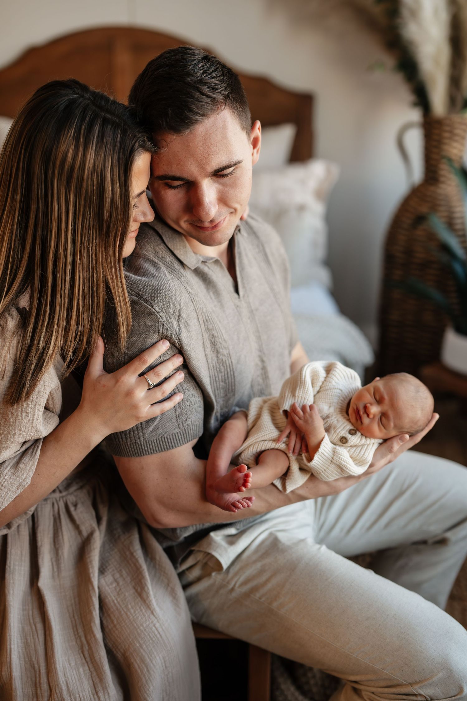 Parents in neutral tones share tender moments with their newborn baby in a series of intimate lifestyle photos.