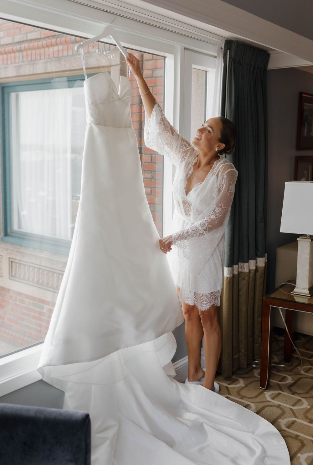 A series of four photos showing someone in a white robe preparing and steaming a wedding dress near a window.