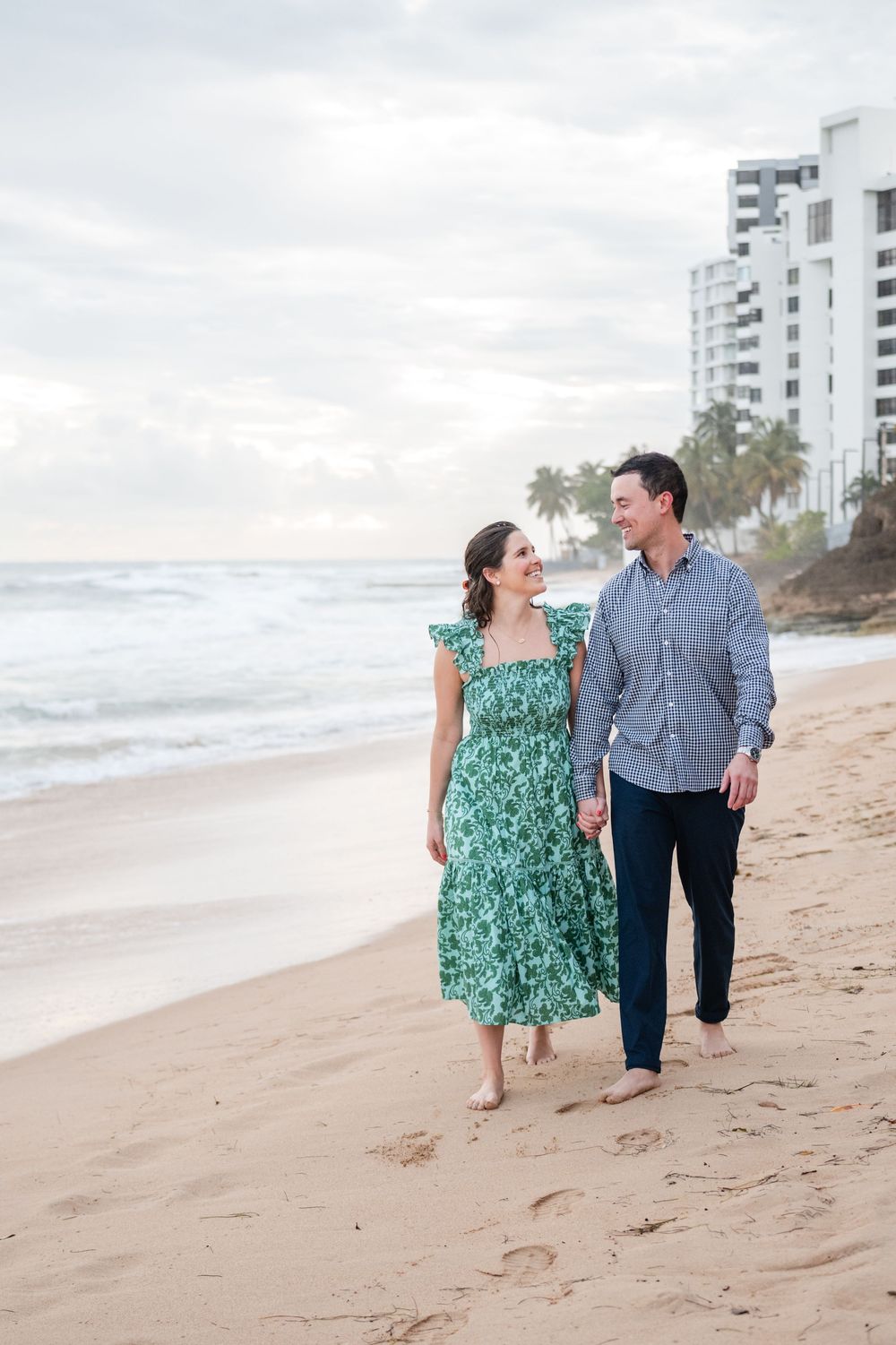 Couple walking along beach with ocean view during engagement session in Condado San Juan Puerto Rico