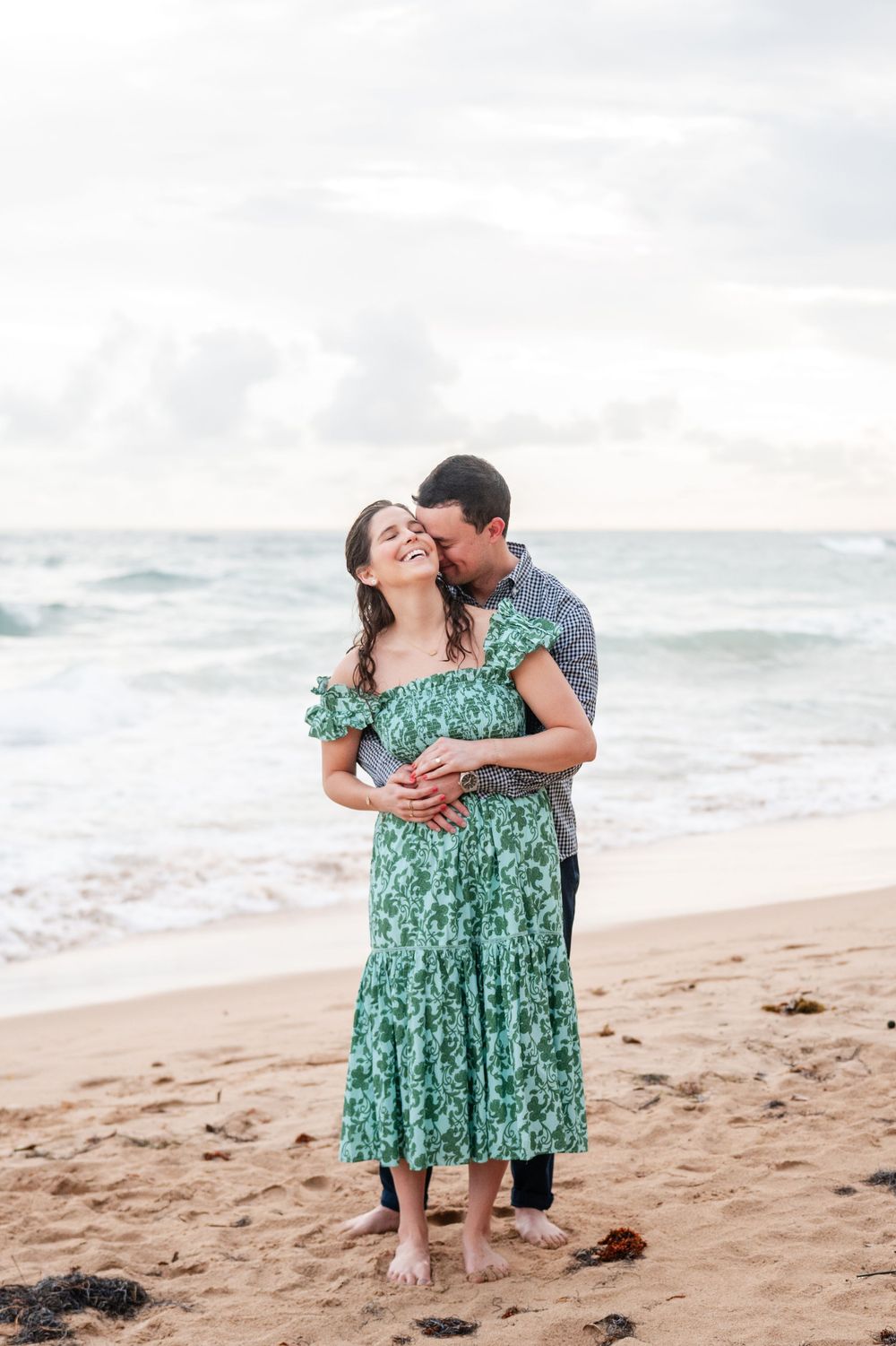 Couple hugging together on beach during engagement session in San Juan Puerto Rico