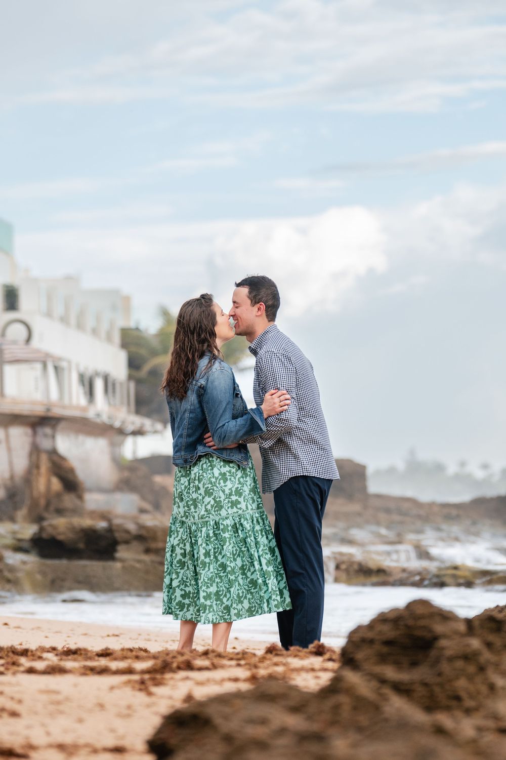 Couple standing together on rocky shoreline during engagement photos in Condado Puerto Rico