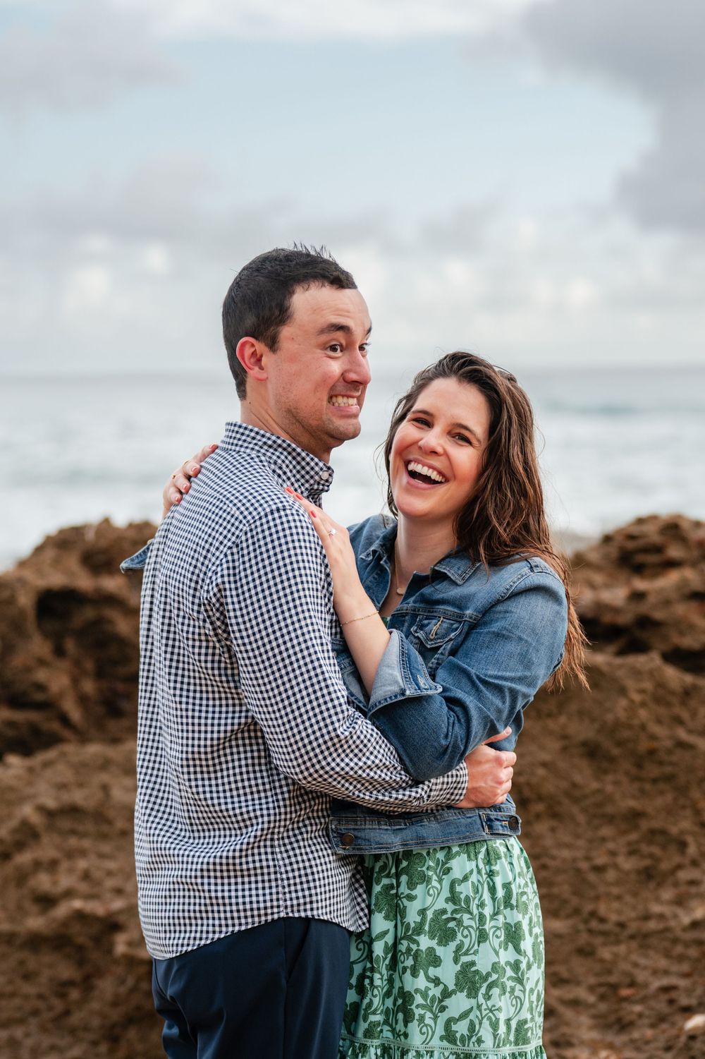 Couple laughing together with ocean view during engagement session in San Juan Puerto Rico