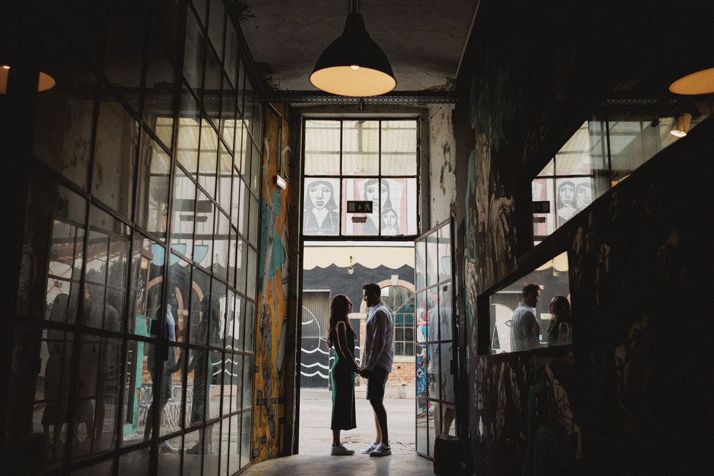 pre wedding photos in Lisbon LX Factory silhouette couple holding hands in industrial doorway