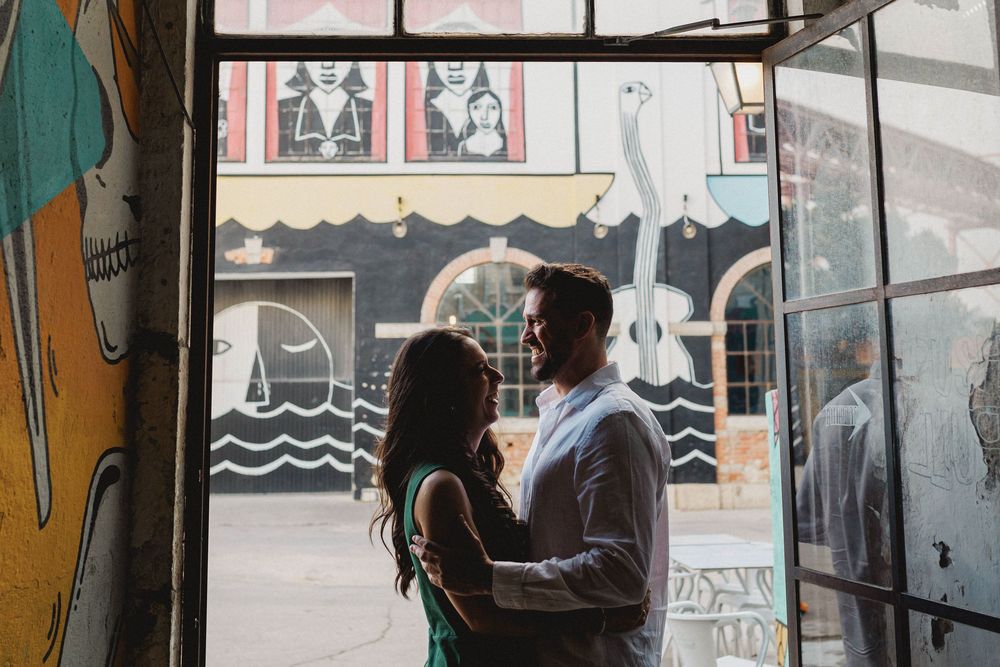 pre wedding photos in Lisbon LX Factory couple hugging framed by urban street art doorway