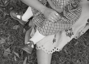 A sequence of black and white photos showing hands folding a paper airplane step by step on grass.