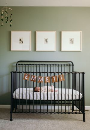 A series of five photos showing a black metal crib against a sage green wall with decorative elements and bedding.