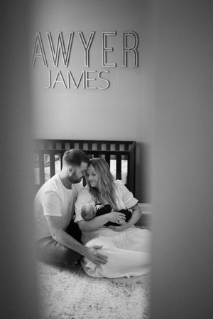 A series of black and white photographs showing tender moments between a parent and baby on a carpeted floor.