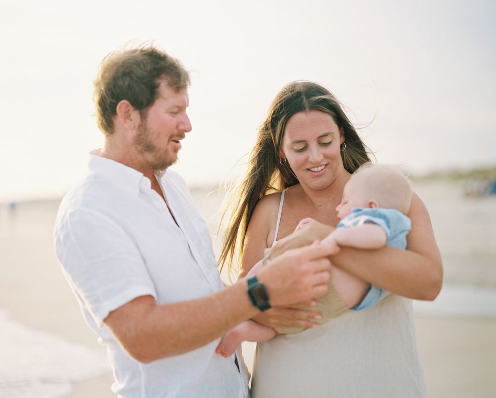Family enjoying a tender moment together on a bright sunny beach.