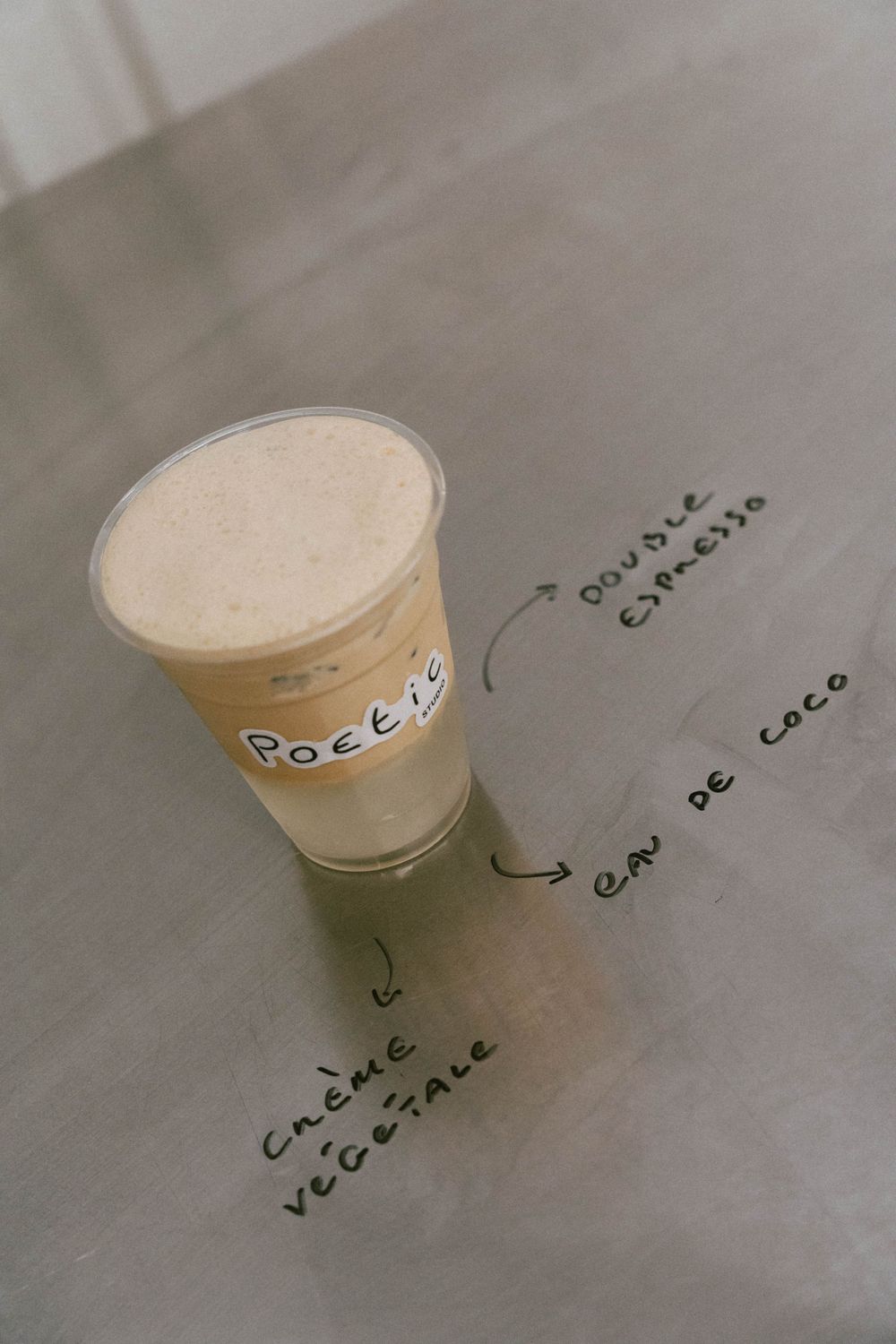 Boisson de café glacé avec double expresso, eau de coco et crème végétale écrite sur la table. photo prise par la meilleure photographe