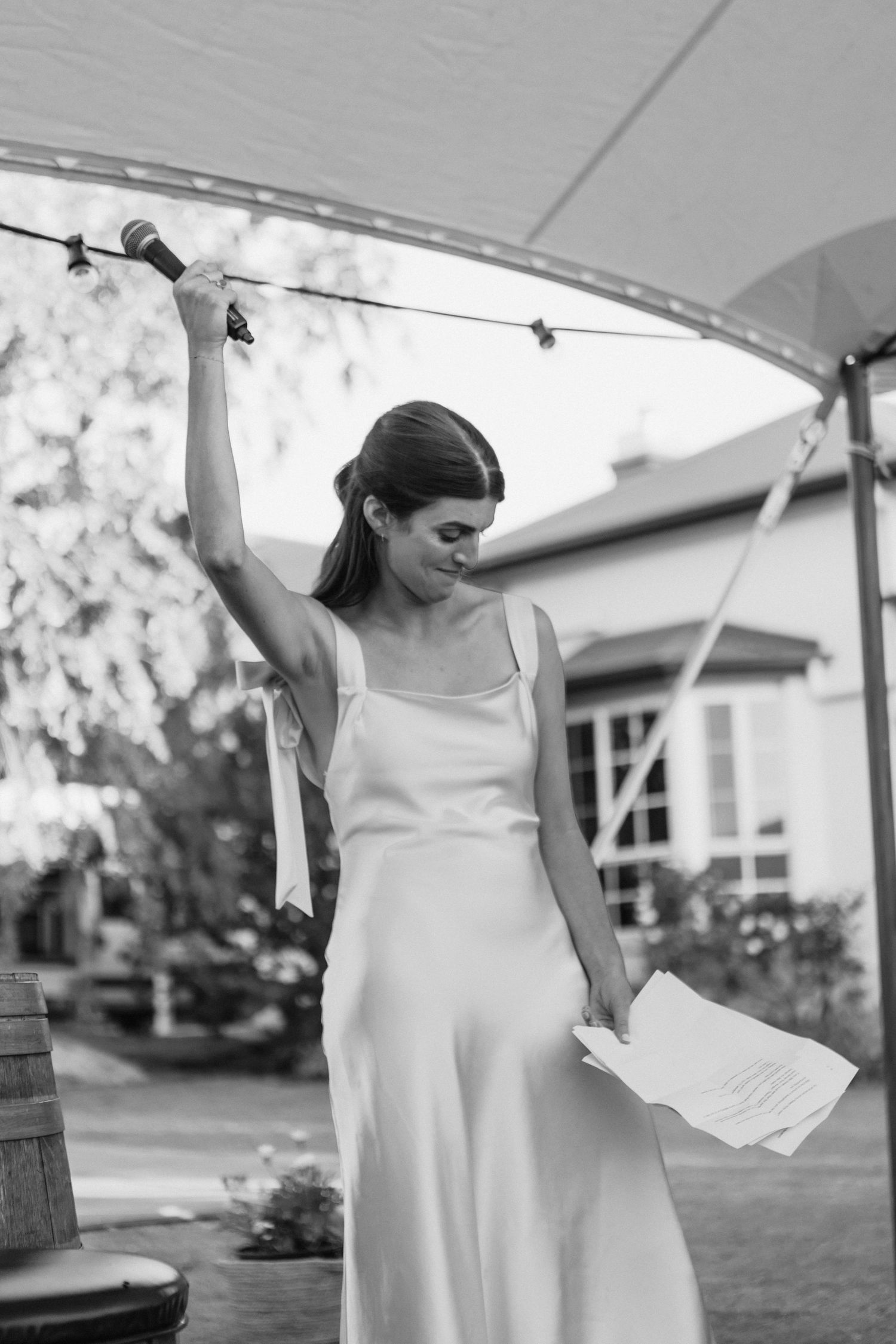 sister of the bride raising a hand during speech at country wedding