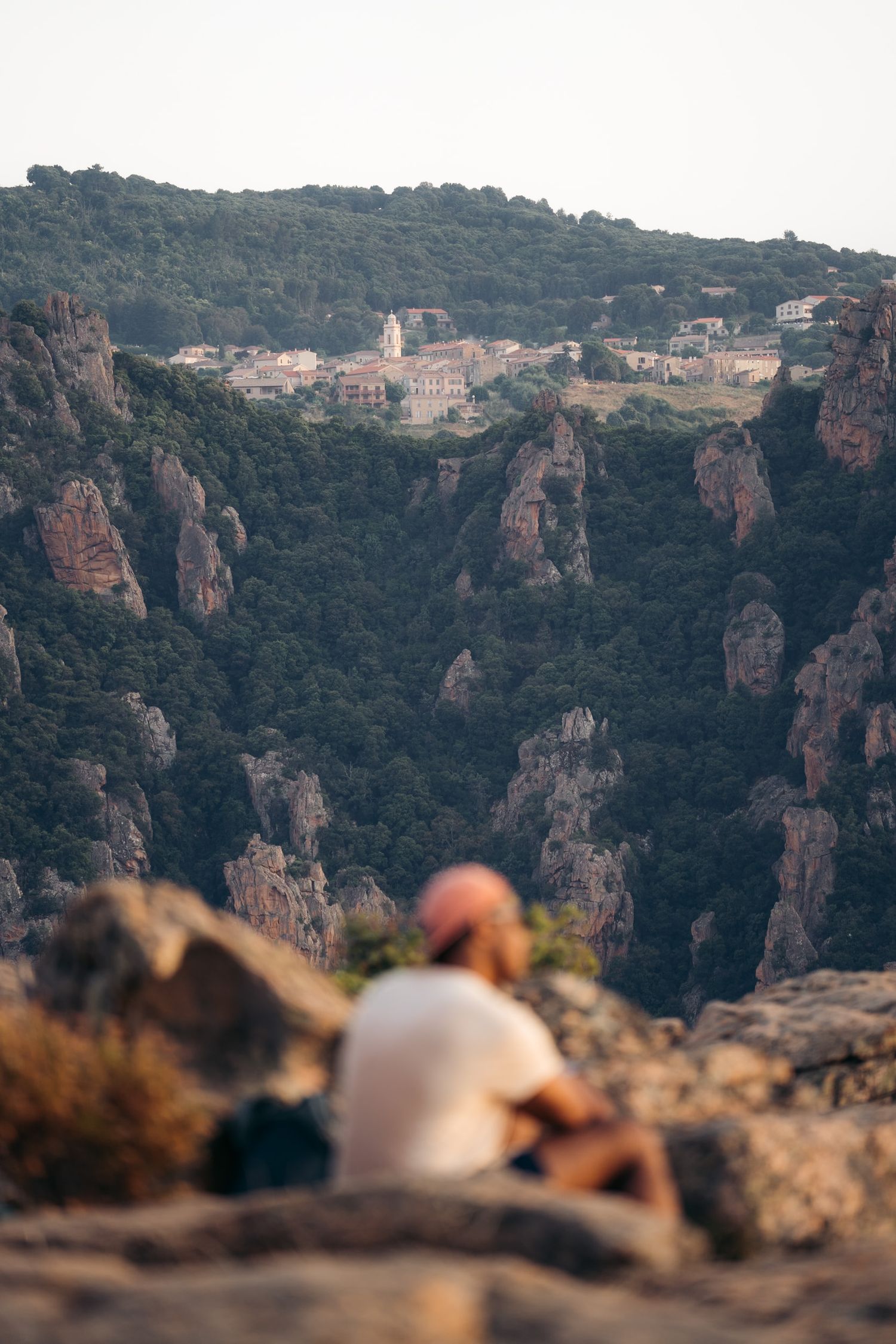 promeneur dans le maquis de porto avec le village de piana en arrière-plan