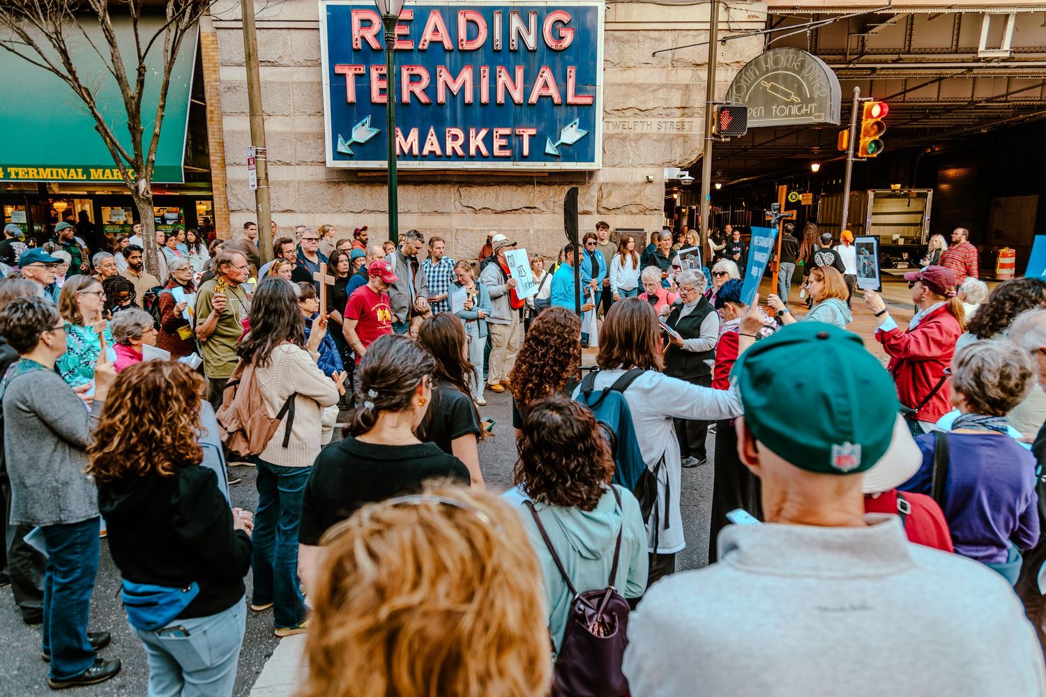 Crowd gathers outside Reading Terminal Market in Philadelphia, PA for a lively outdoor event.