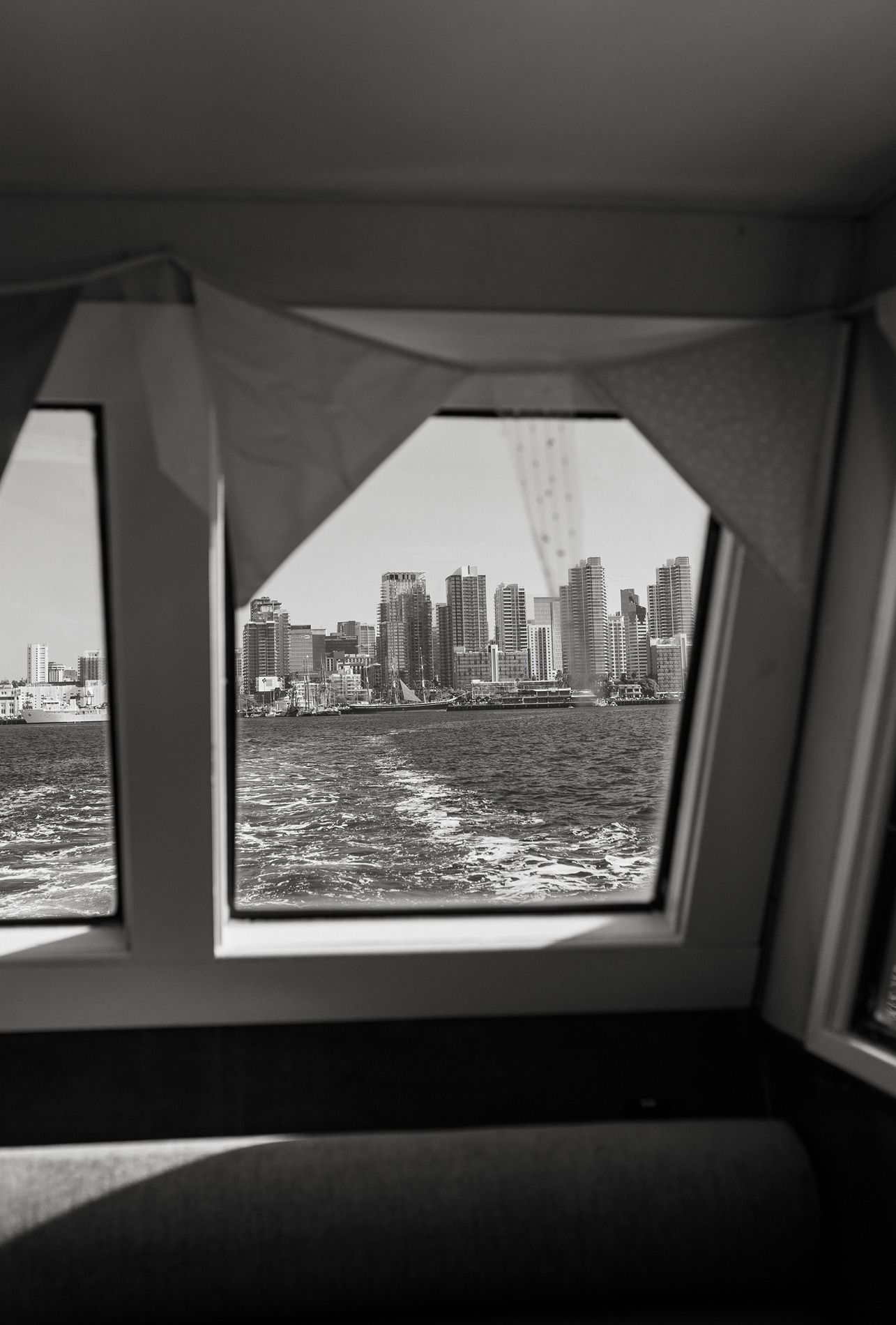 Black and white panoramic sequence showing a cityscape view of San Diego through boat windows.