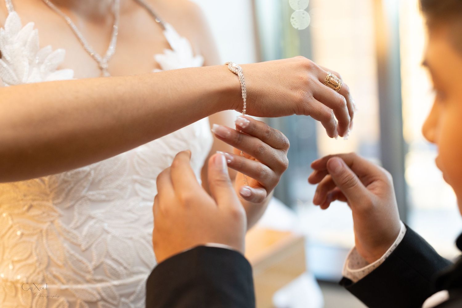 Close-up shot of hands exchanging wedding rings during ceremony.