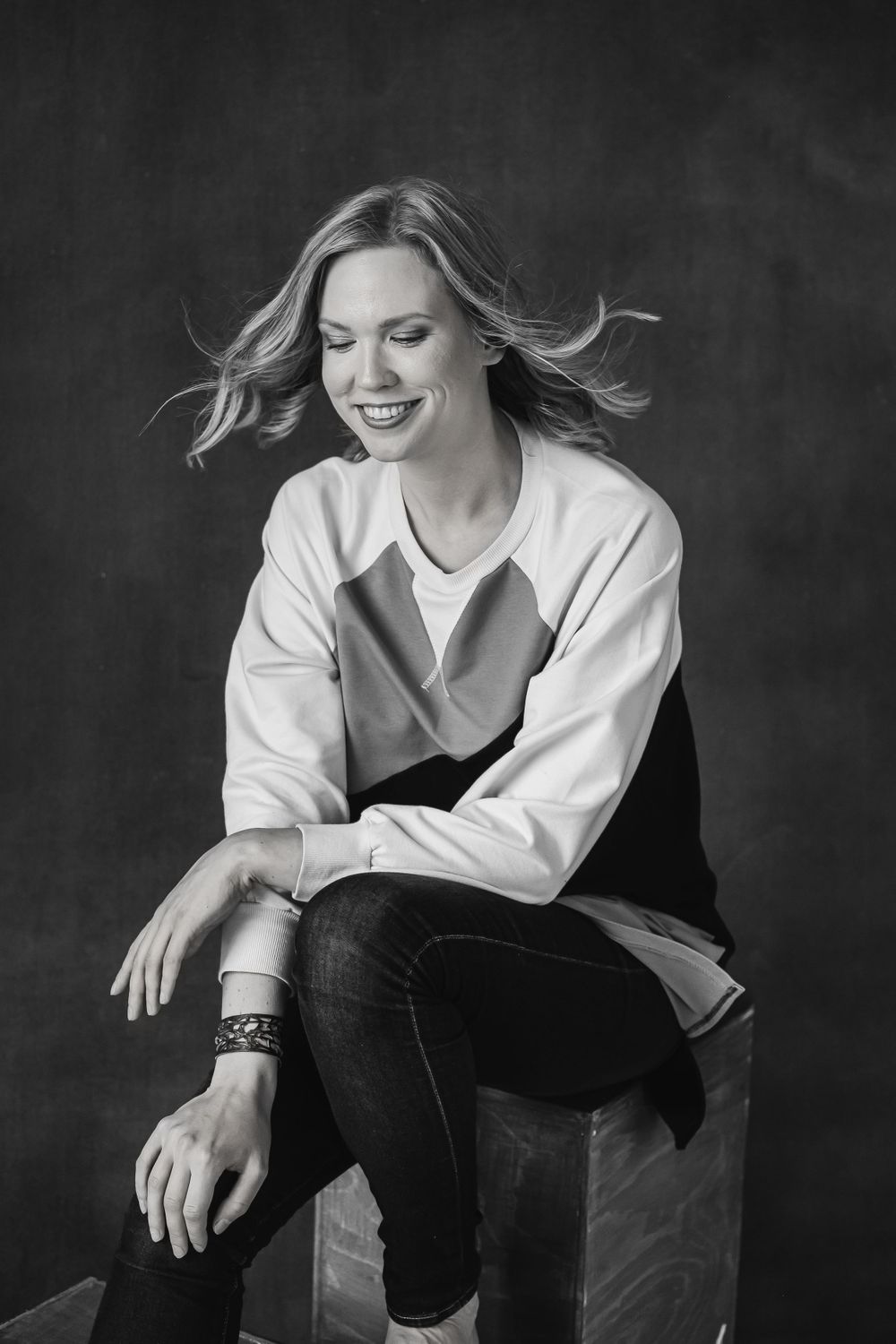 Black and white portrait with flowing hair and casual white top.