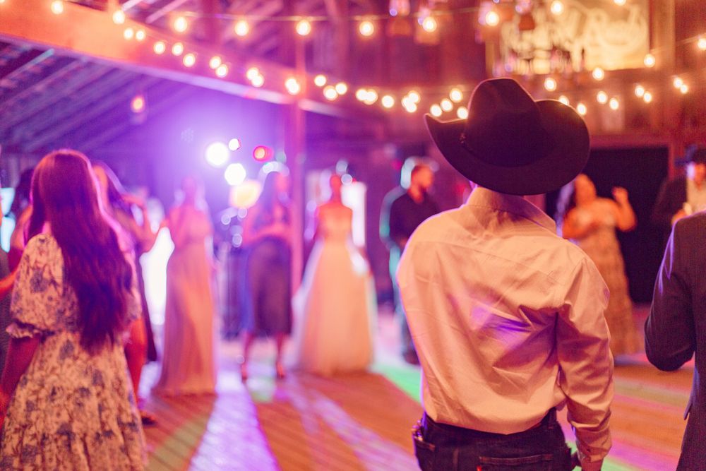 Wedding reception dance floor with colorful purple and pink lighting creating a festive atmosphere.