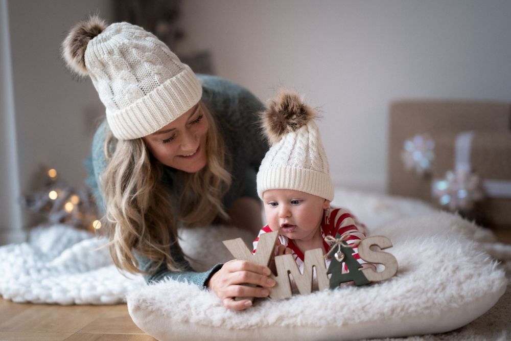 Süßer Wintermoment, eingefangen auf weißem Fell mit passenden Strickmützen mit Bommel.