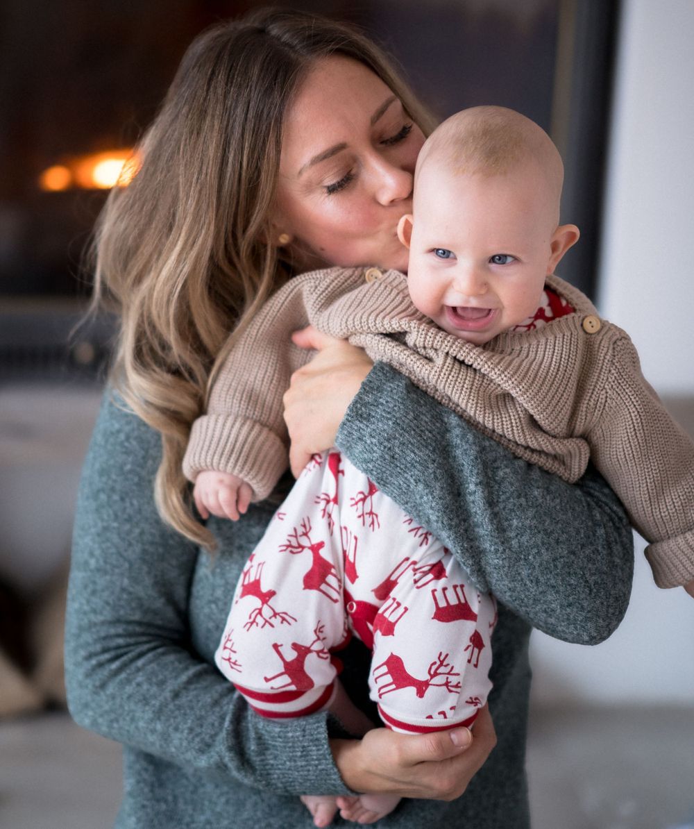 Gemütlicher Wintermoment im grauen Pullover mit festlicher rot-weiß gemusterter Kleidung.