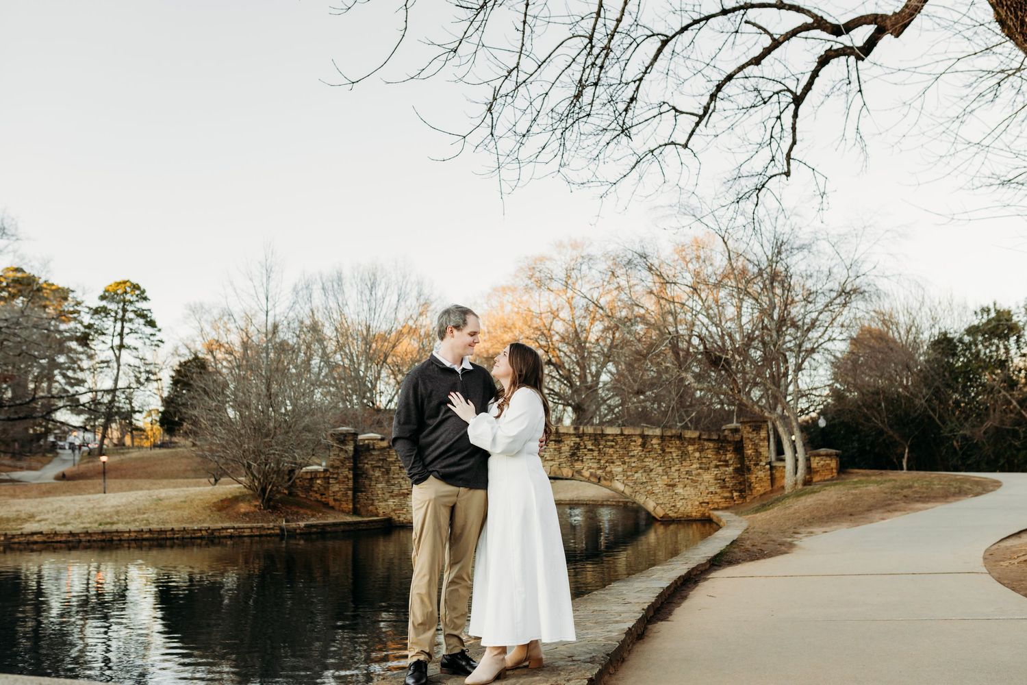 A winter engagement photo series showing romantic moments along a stone bridge pathway.