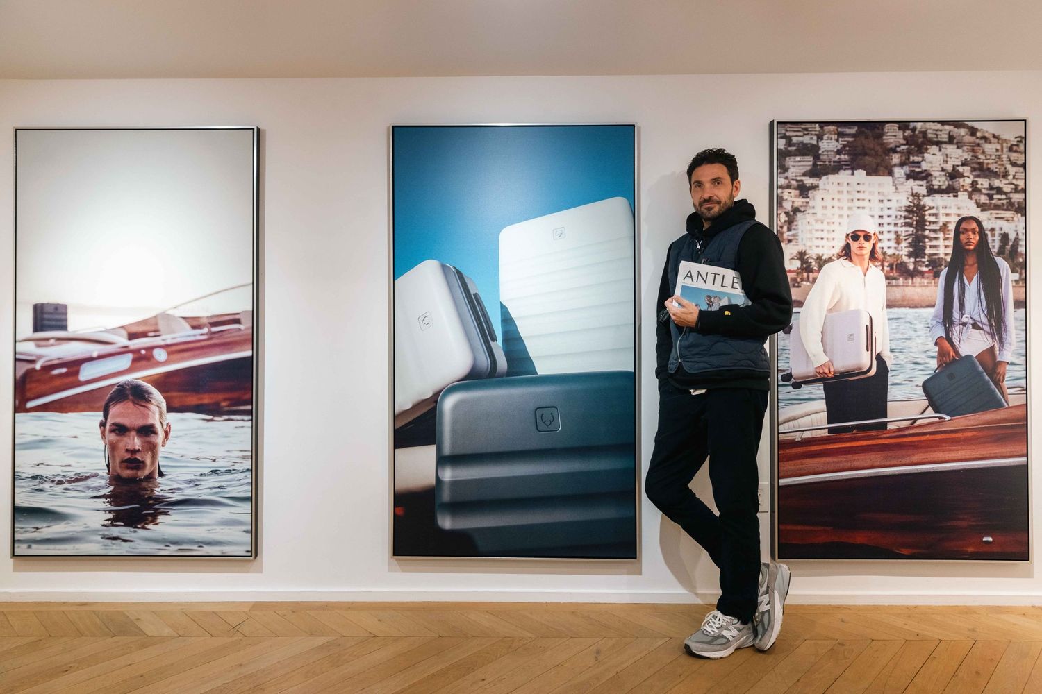 Gallery wall featuring large format photographs with person standing beside artistic displays.