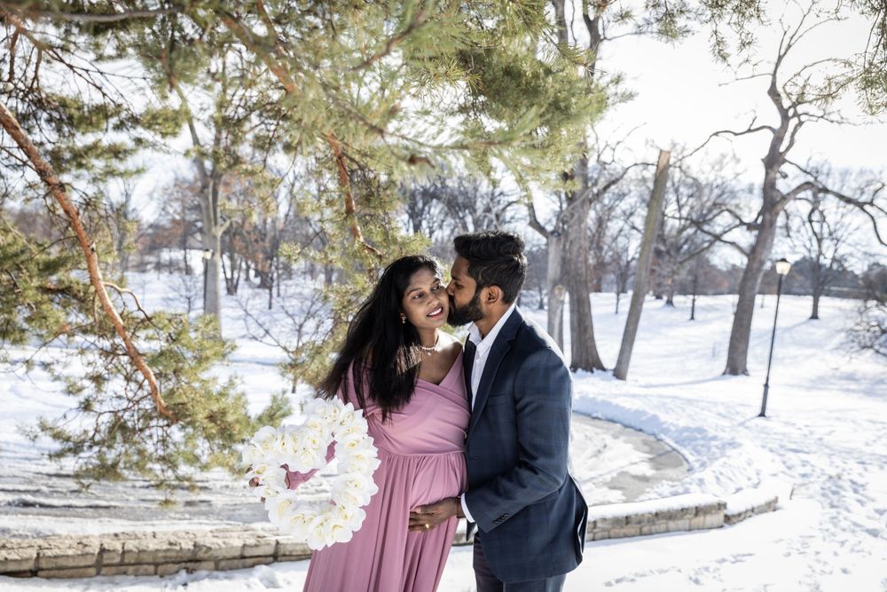 Couple poses together in snowy winter scene during outdoor photoshoot.