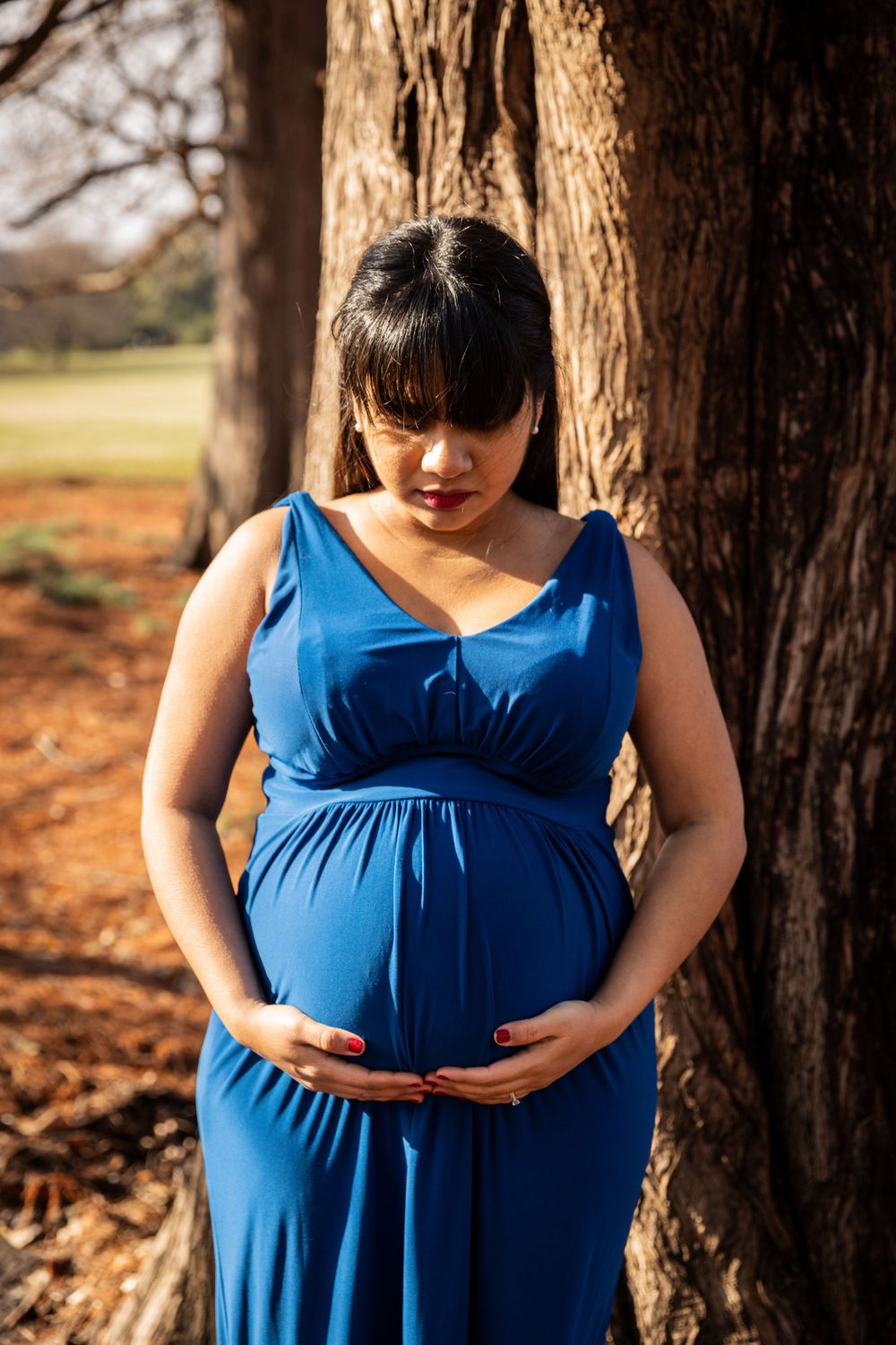Close-up shots of pregnant woman in blue dress against autumn trees.