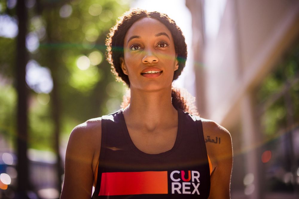Athlete wearing a black tank top with "Clip Rex" text smiles during outdoor workout.