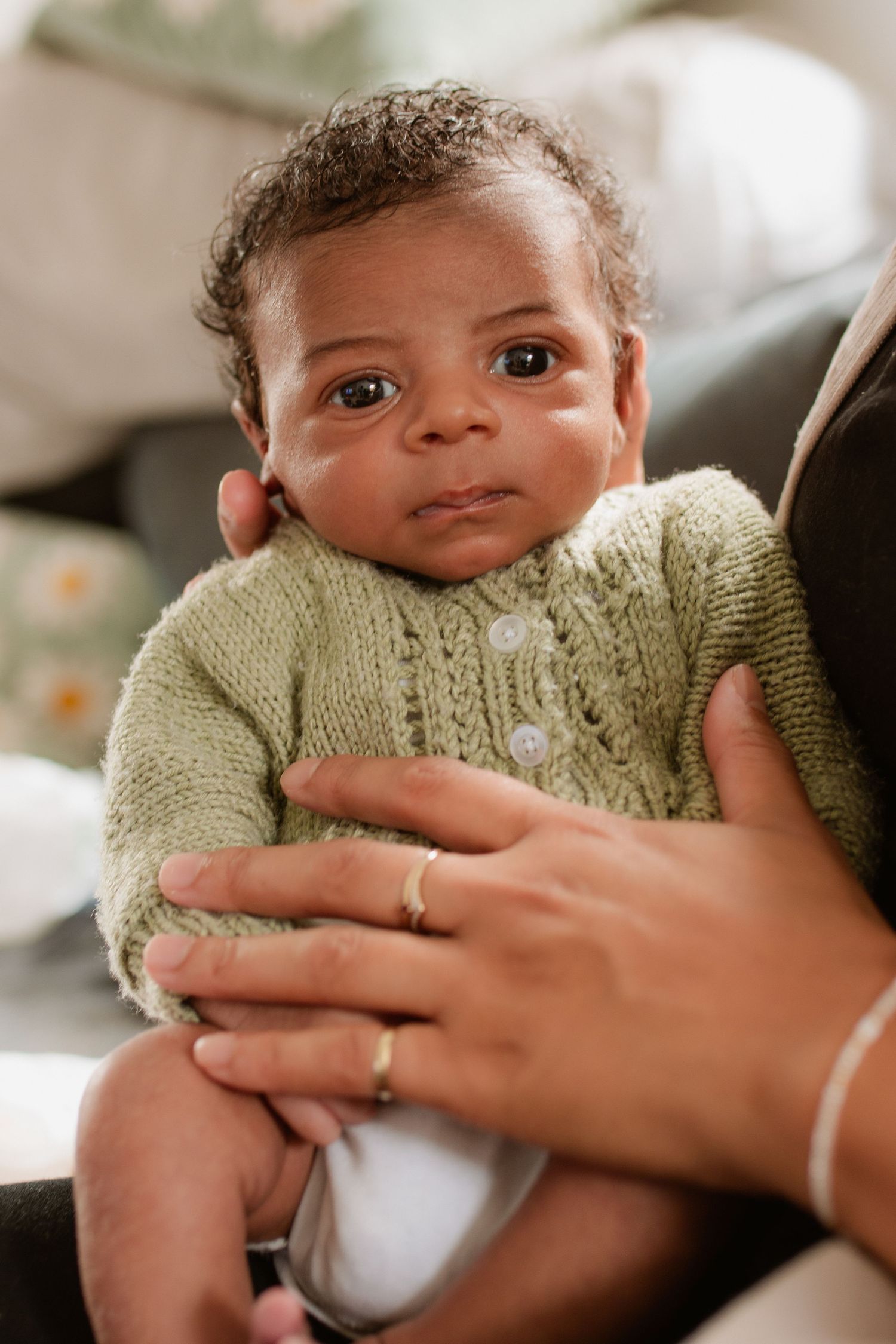 Baby wearing mint green sweater during lifestyle photo session.