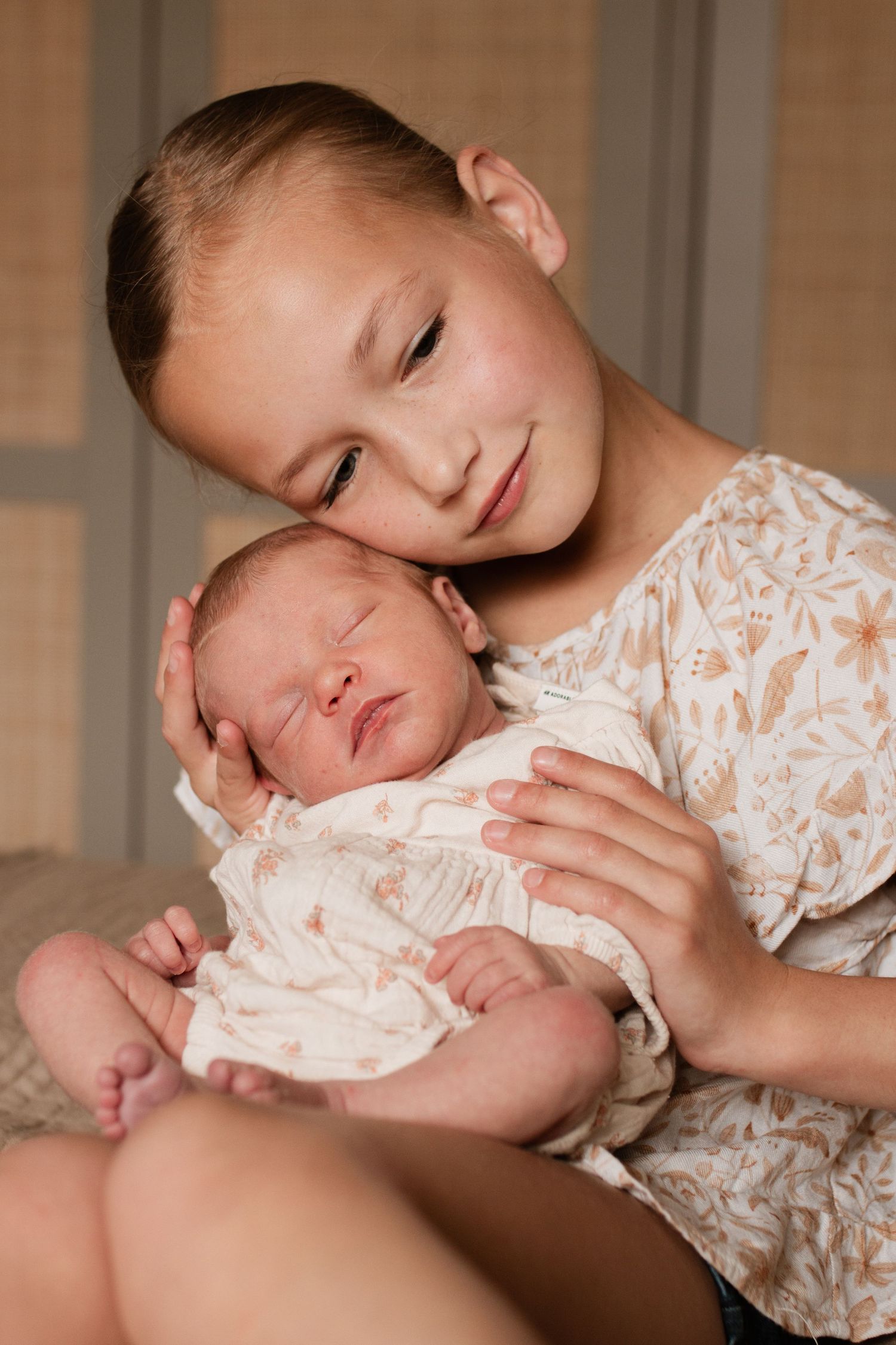 Gentle nurturing moment captured in warm natural light indoors.
