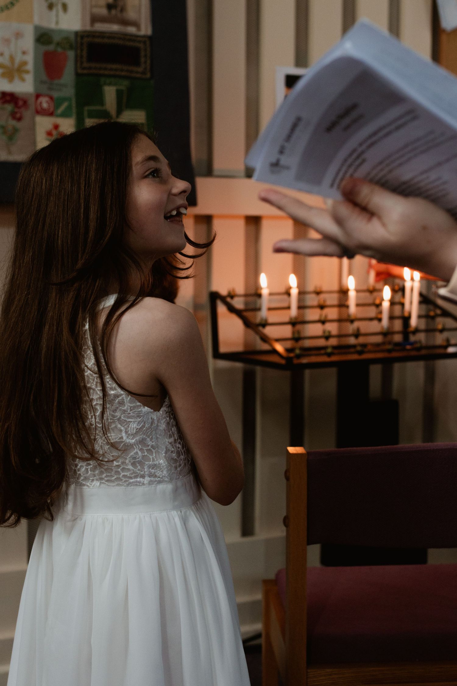 A church ceremony with candles lit in the background creates a sacred atmosphere.