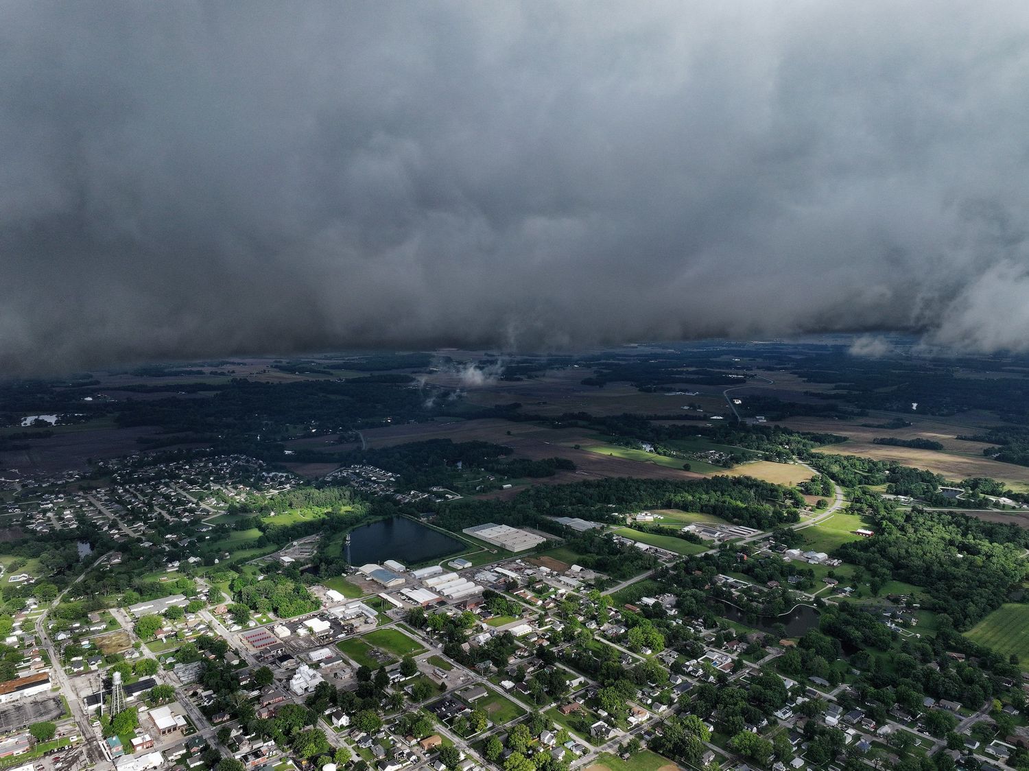 Aerial view of suburban town with dark storm clouds looming overhead.