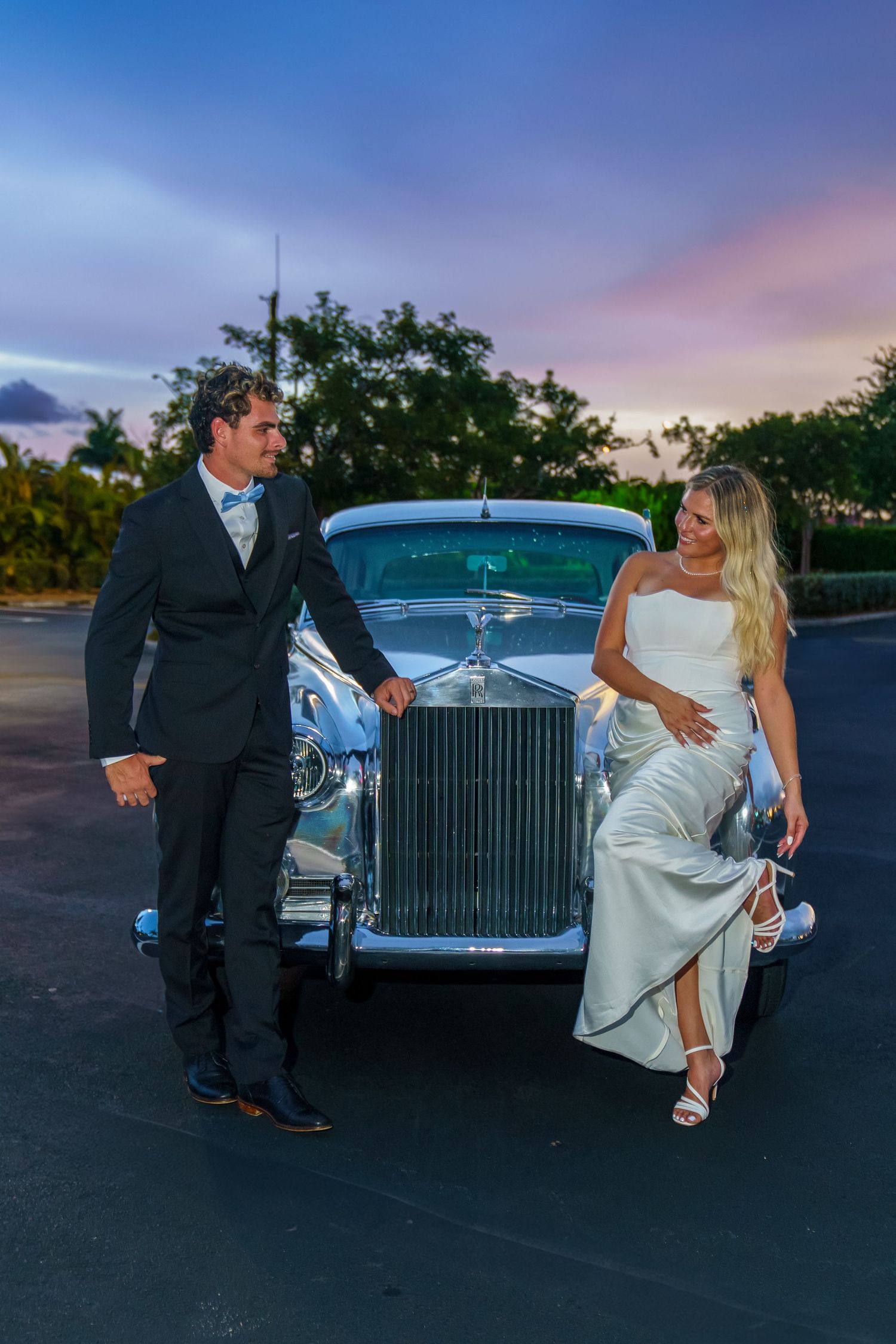 Bride and groom embracing with glowing Hard Rock Guitar Hotel in the night sky background, romantic South Florida wedding portrait