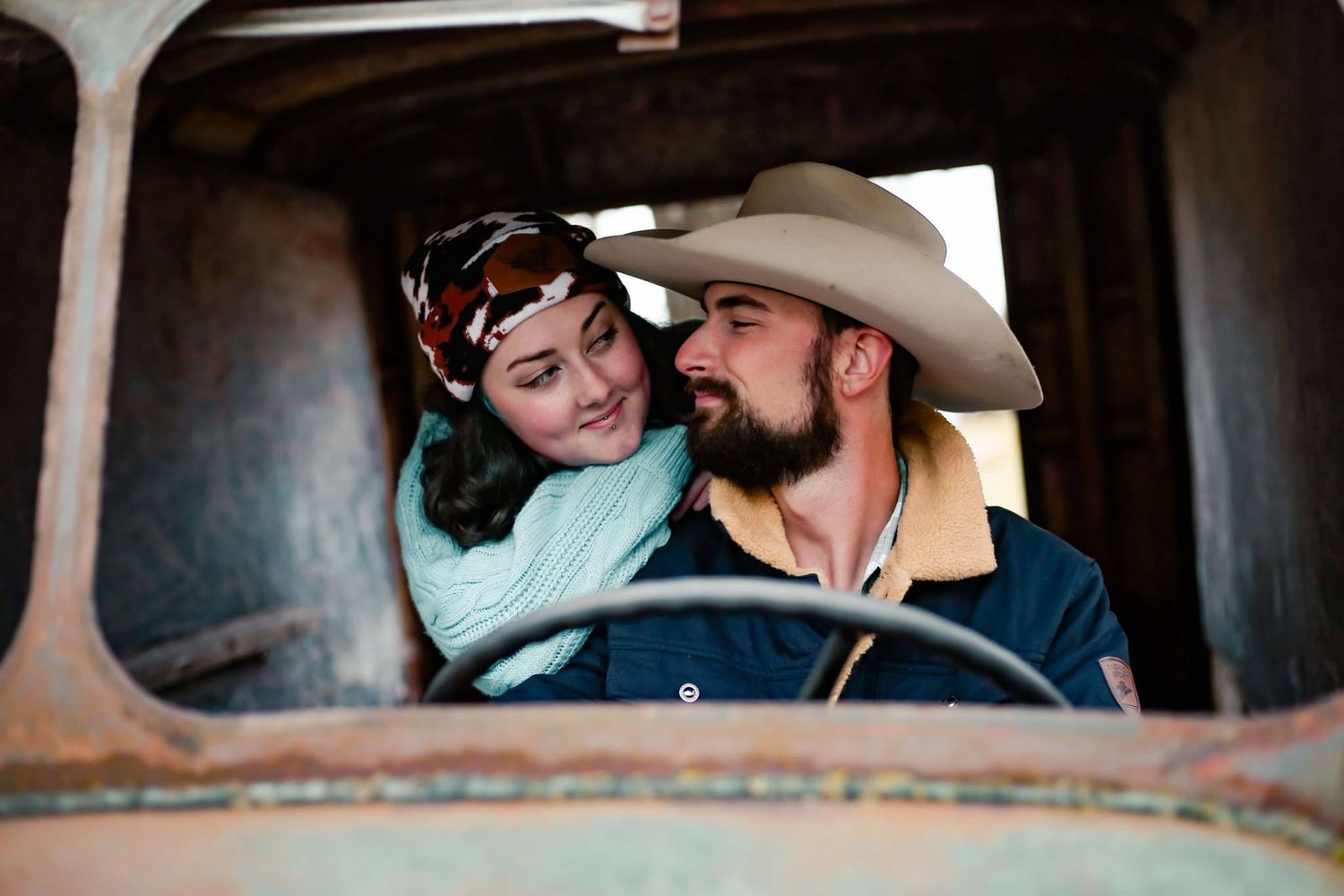 A cozy couple shares a romantic moment in front of a rustic greenhouse at sunset.