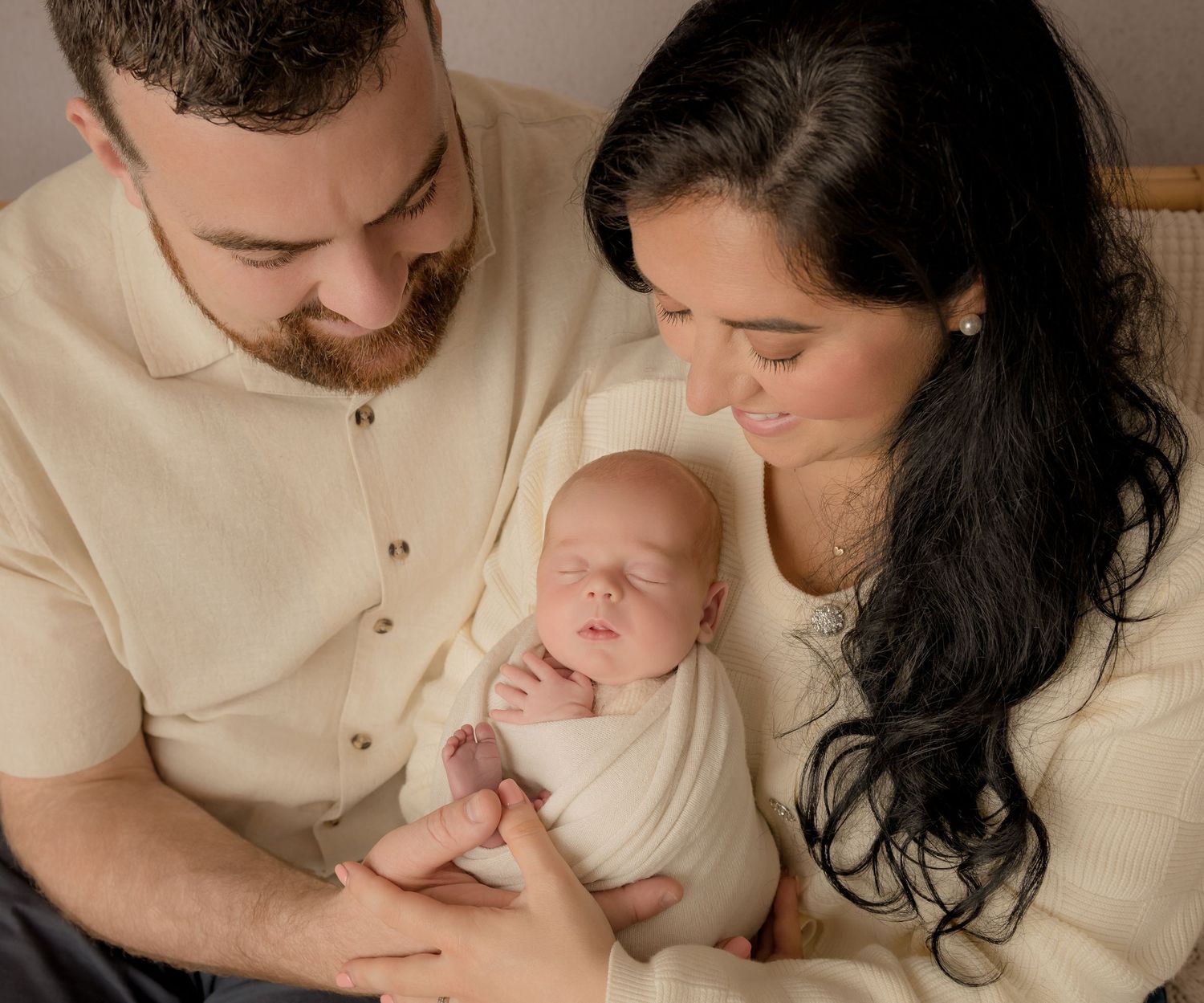 A series of tender family moments showing parents with their newborn baby in warm, neutral-toned portraits.