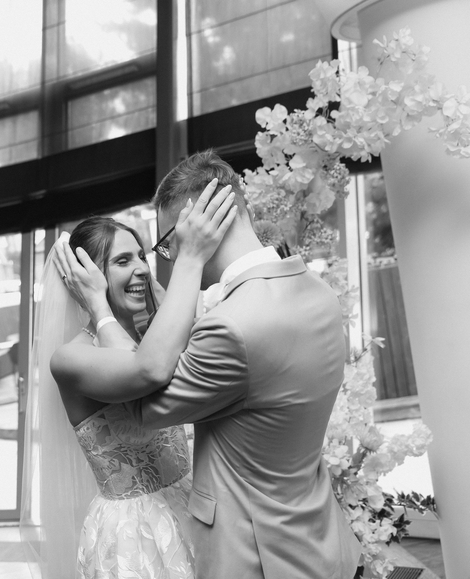 A black and white photo series shows a couple dancing and embracing while surrounded by white floral decorations.