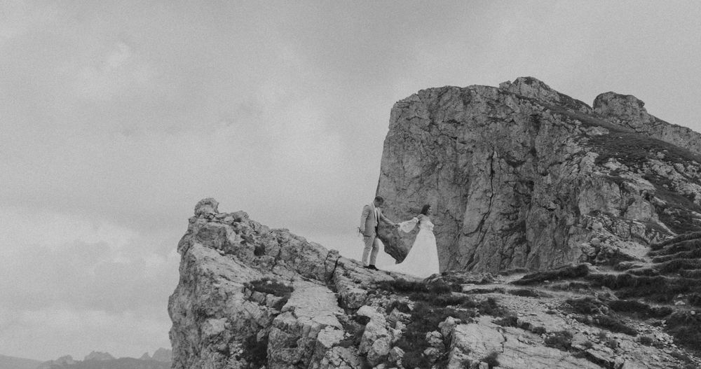 A series of rugged mountain peaks and rock formations against a cloudy sky in a dramatic landscape view.