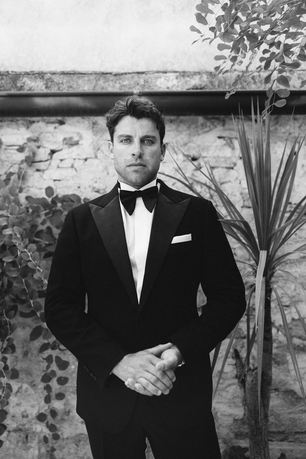 A series of black and white photographs showing men in formal tuxedos and bow ties against a textured stone wall. Hvar, Croatia