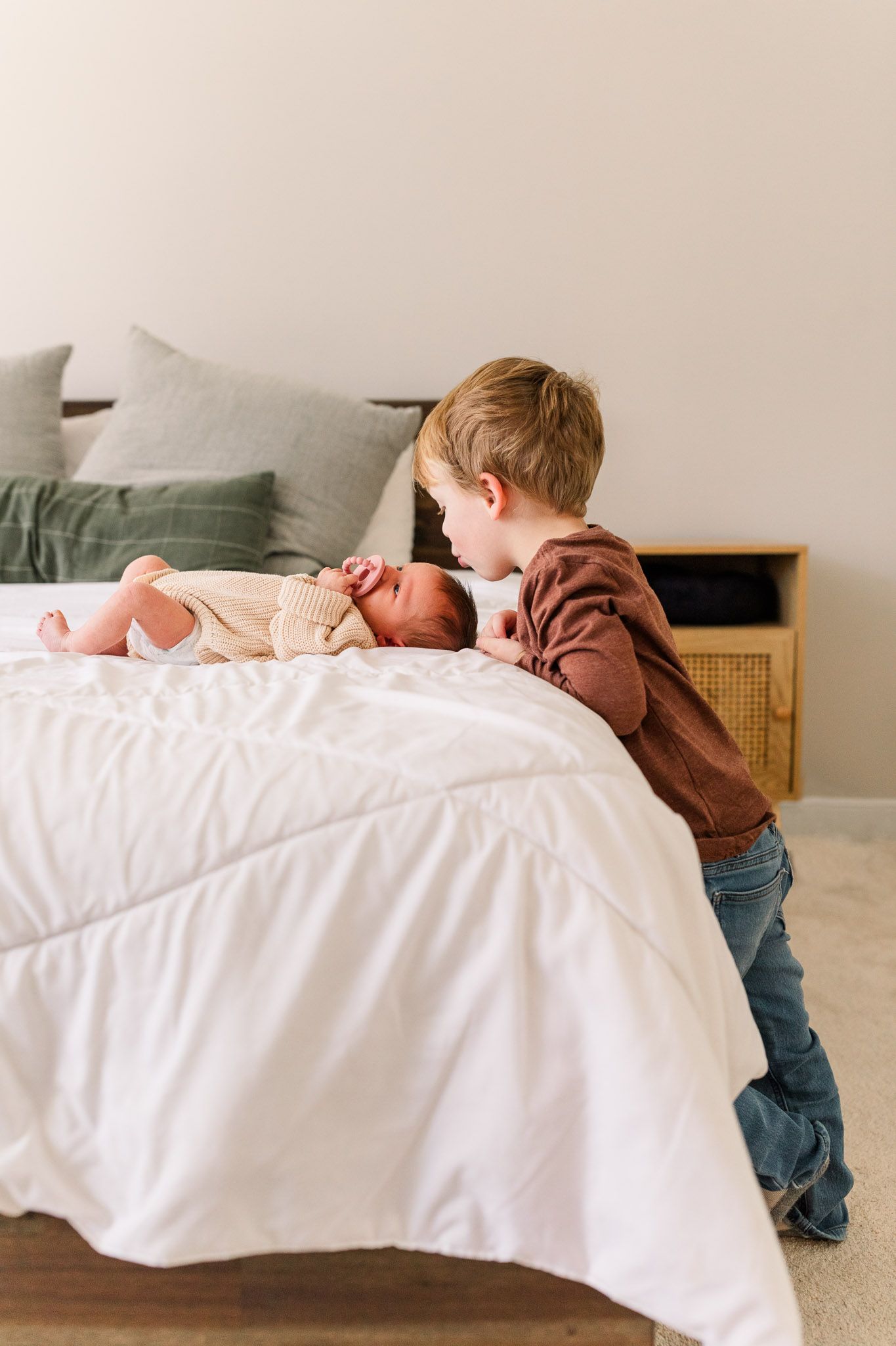 Richmond Virginia newborn photographer documents toddler brother kissing baby sister's head.