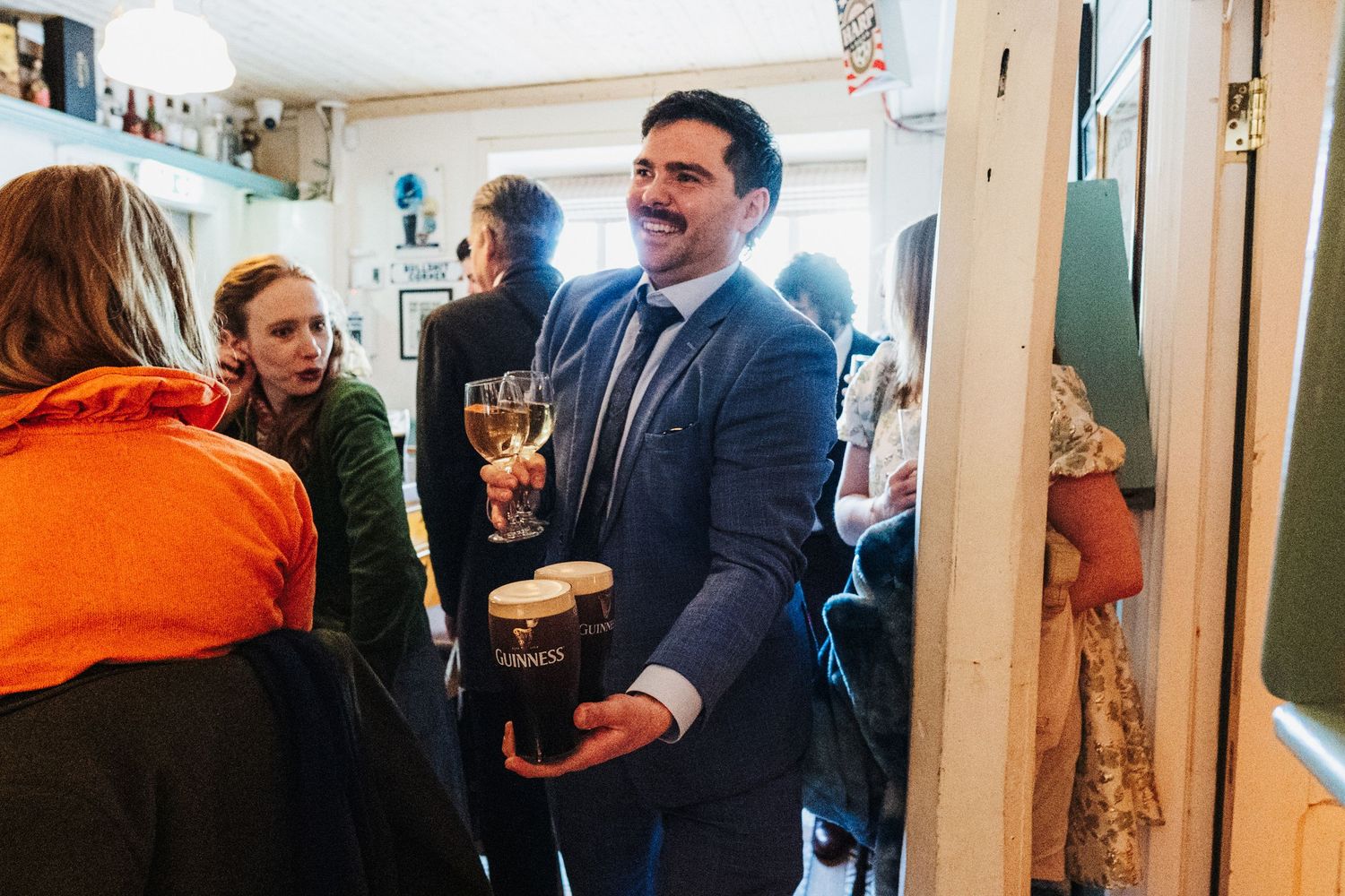 People networking and mingling at a professional business event in a bright office hallway.