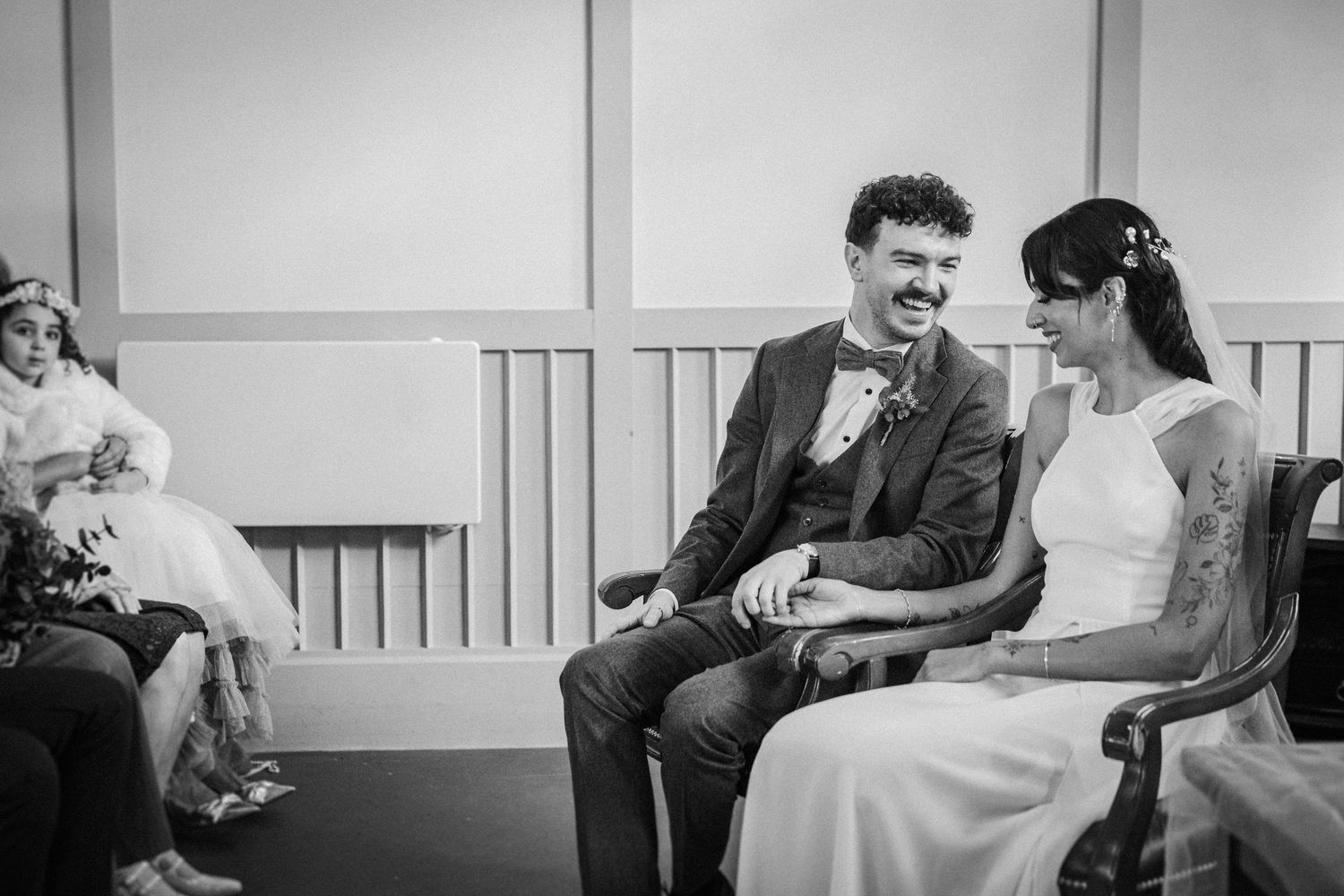 Black and white photo series showing candid moments of a couple laughing and interacting on a couch.