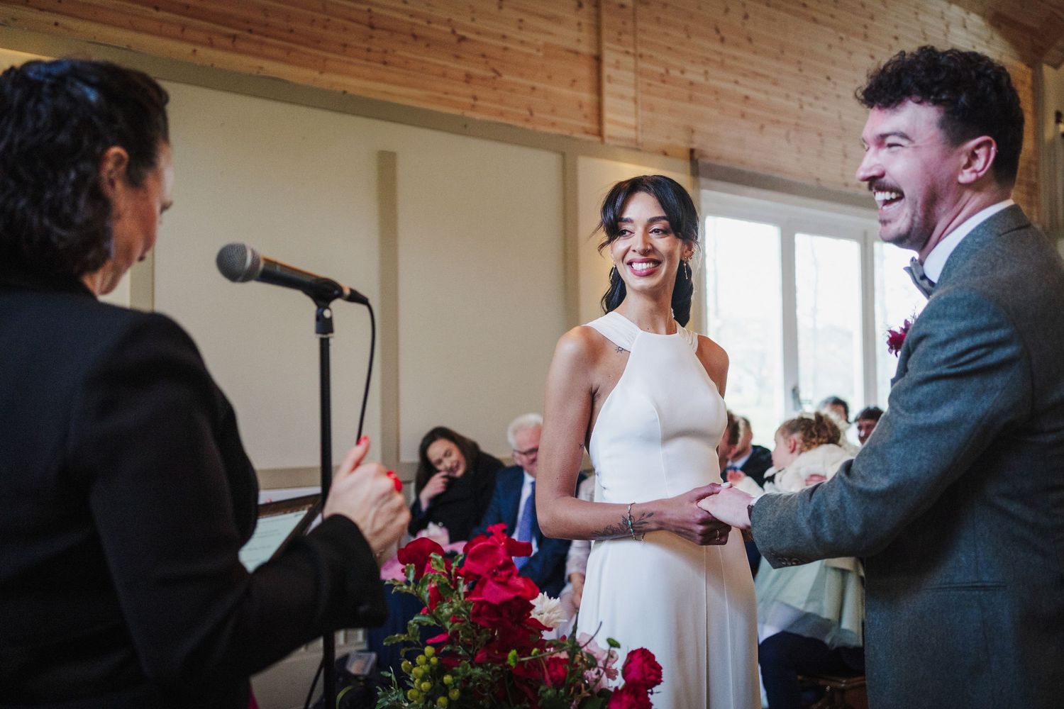 A series of candid wedding ceremony moments showing interactions between participants at an indoor venue.