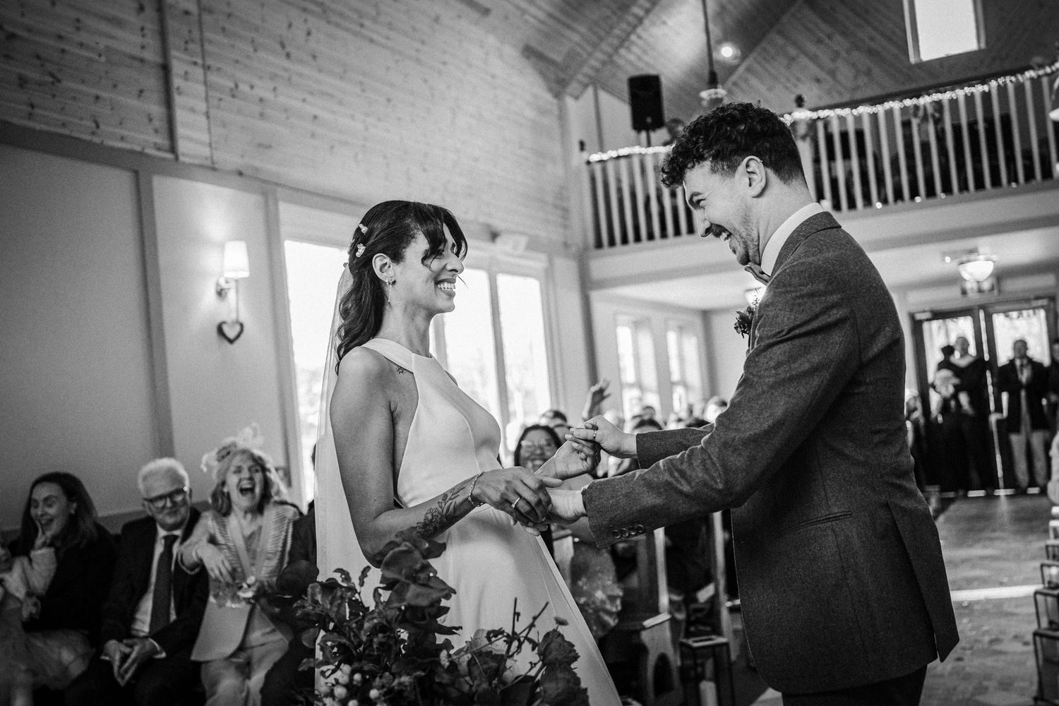 Black and white wedding reception photos showing guests dancing and celebrating at an elegant indoor venue.