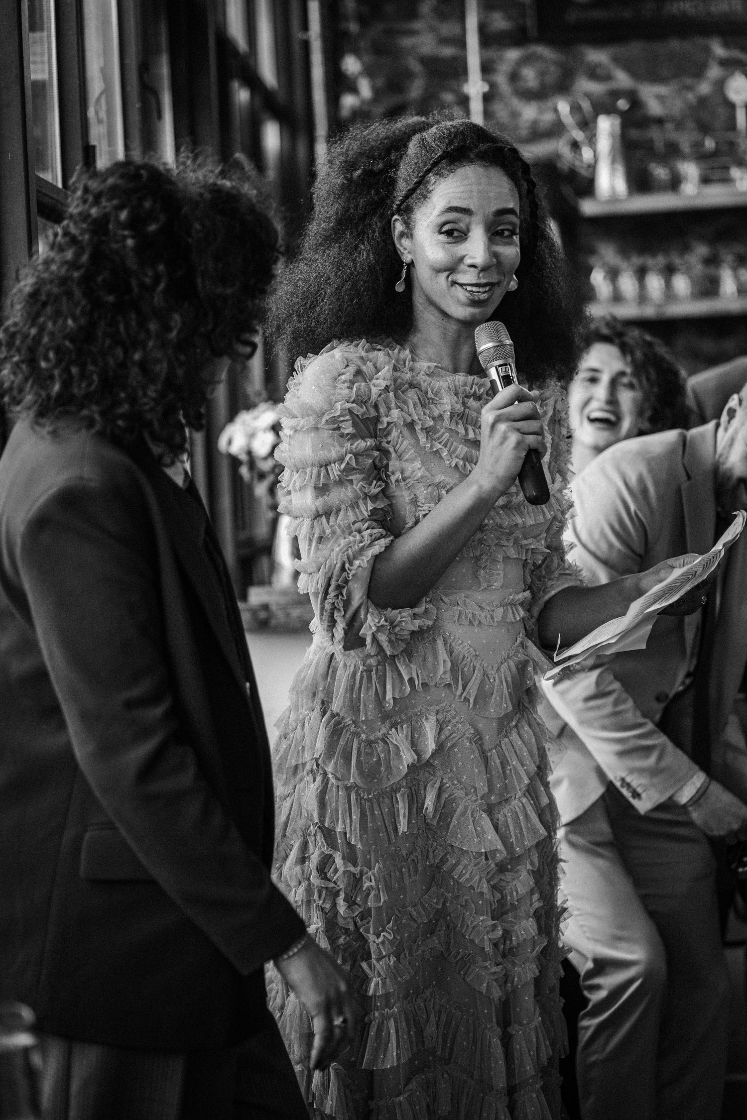 A sequence of black and white photos showing a joyful moment between two people laughing and embracing.