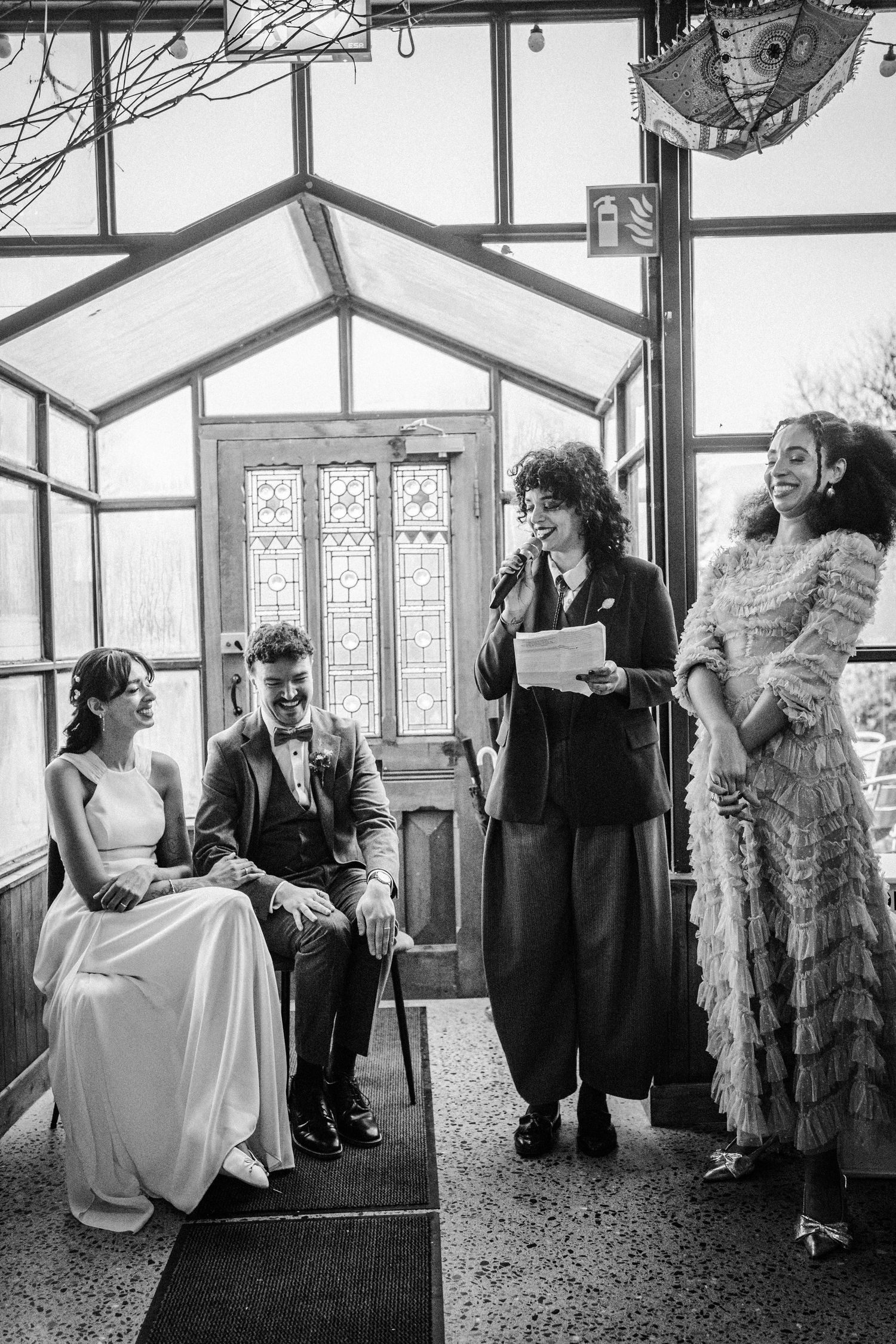 A black and white photo series showing candid moments between a bride and groom in a sunlit conservatory setting.