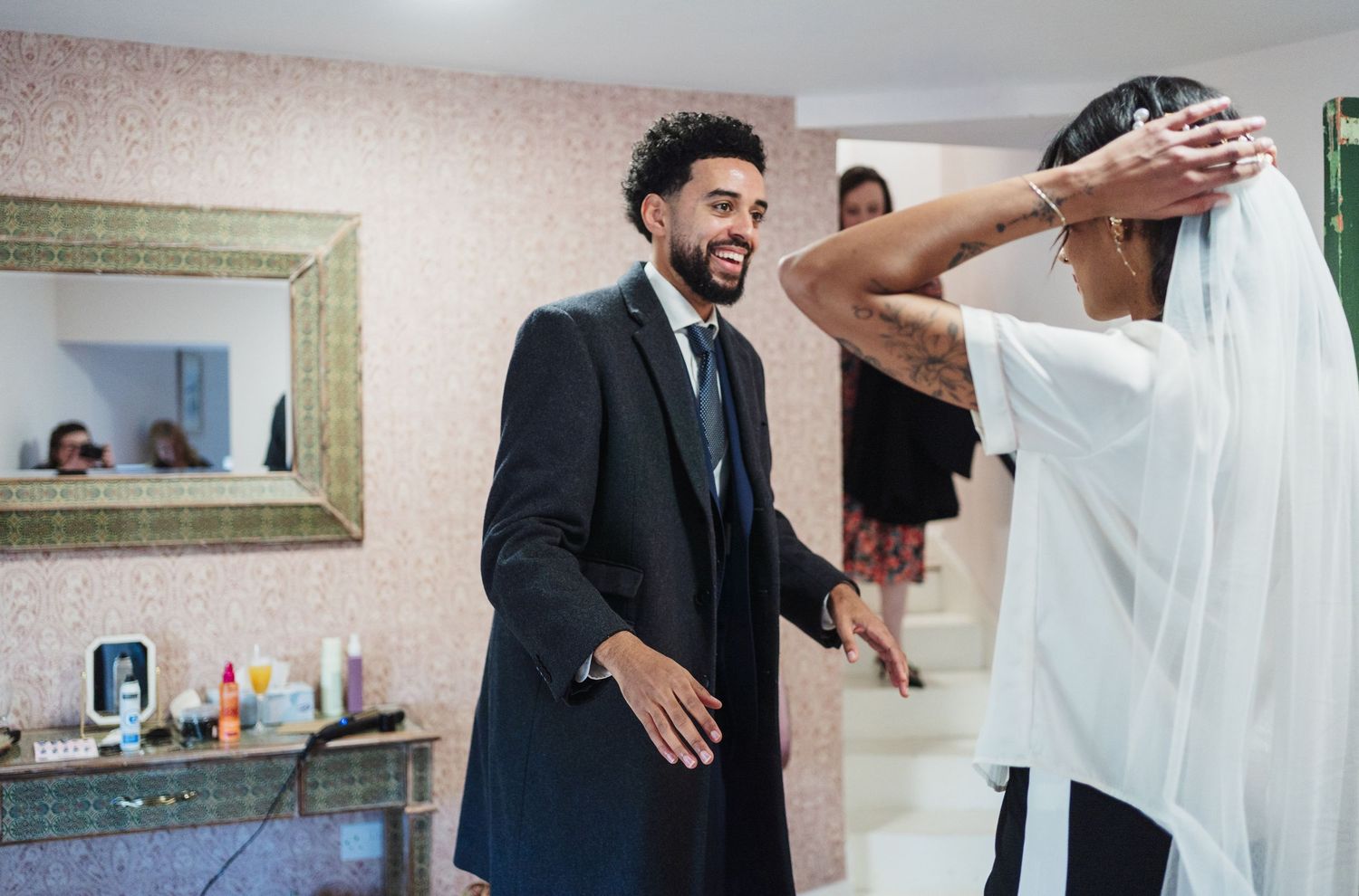 A joyful moment captured during a wedding preparation as the groom reacts with excitement while getting ready.